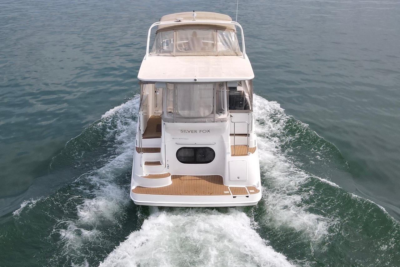 2004 Silverton 39 Motor Yacht cruising on open water, rear view.