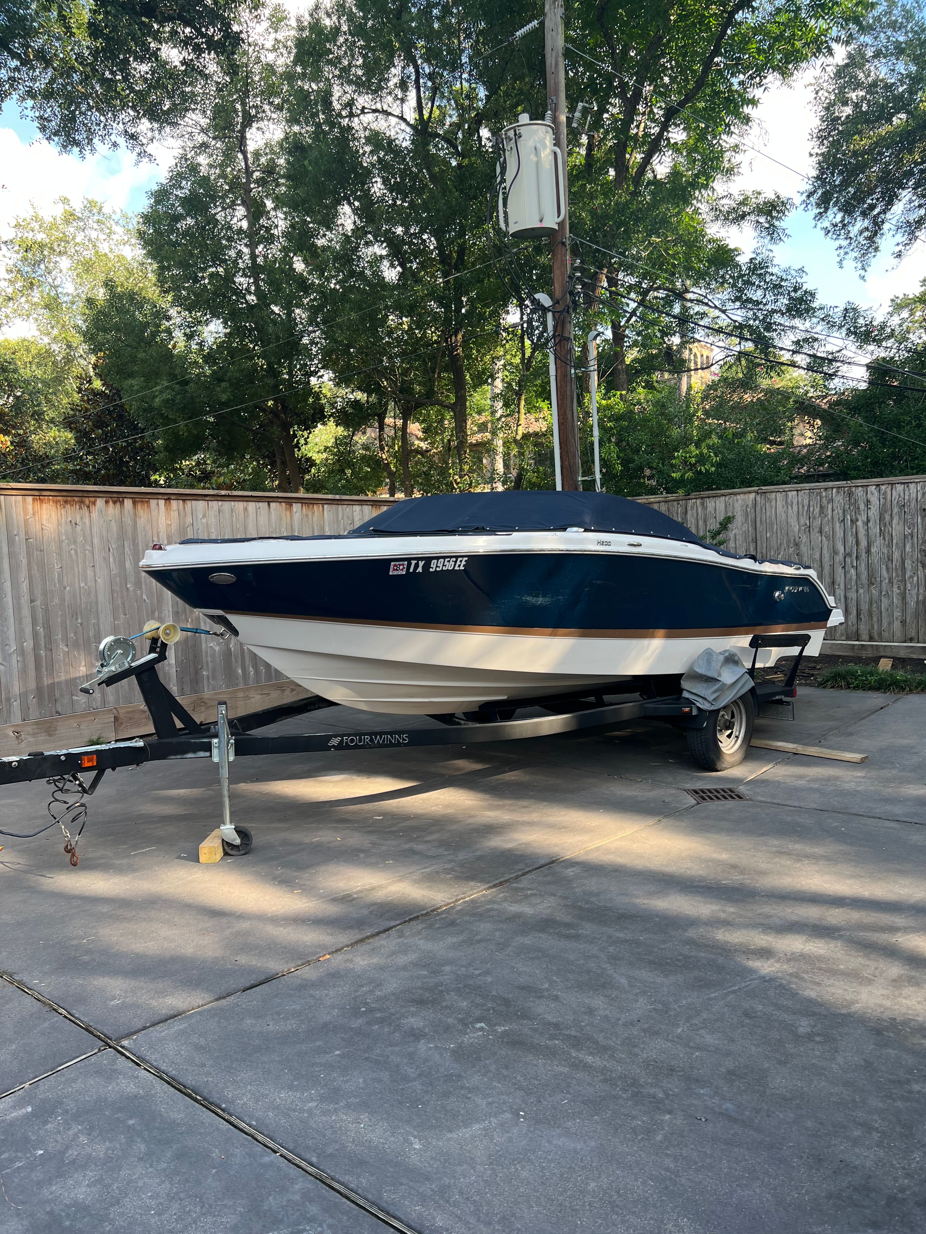 2017 Four Winns H230 boat parked on trailer outdoors.