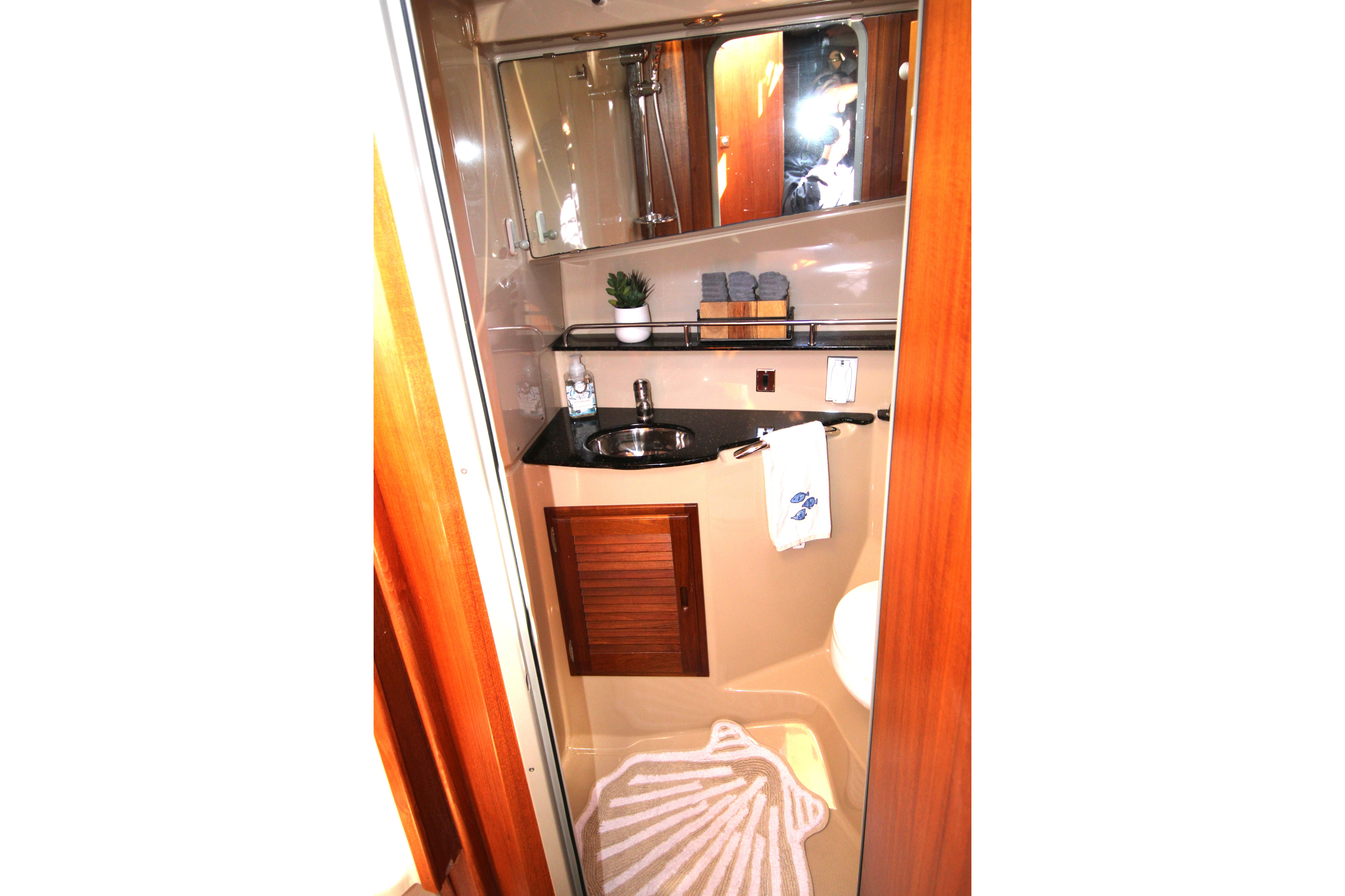 2013 Ranger Tugs R-31 CB bathroom with sink, mirror, and wooden accents.