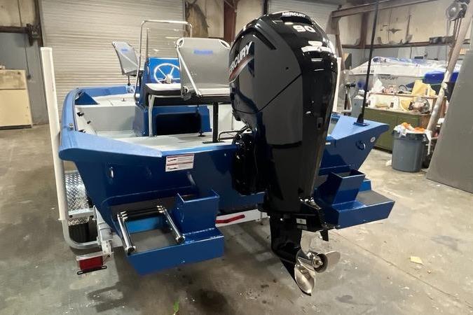 2025 SeaArk Shadow 187T boat with Mercury outboard motor in a workshop setting.