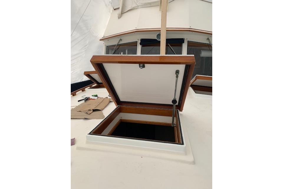 Open hatch on 1983 Grand Banks 42 Motoryacht deck, showcasing wooden trim and interior access.
