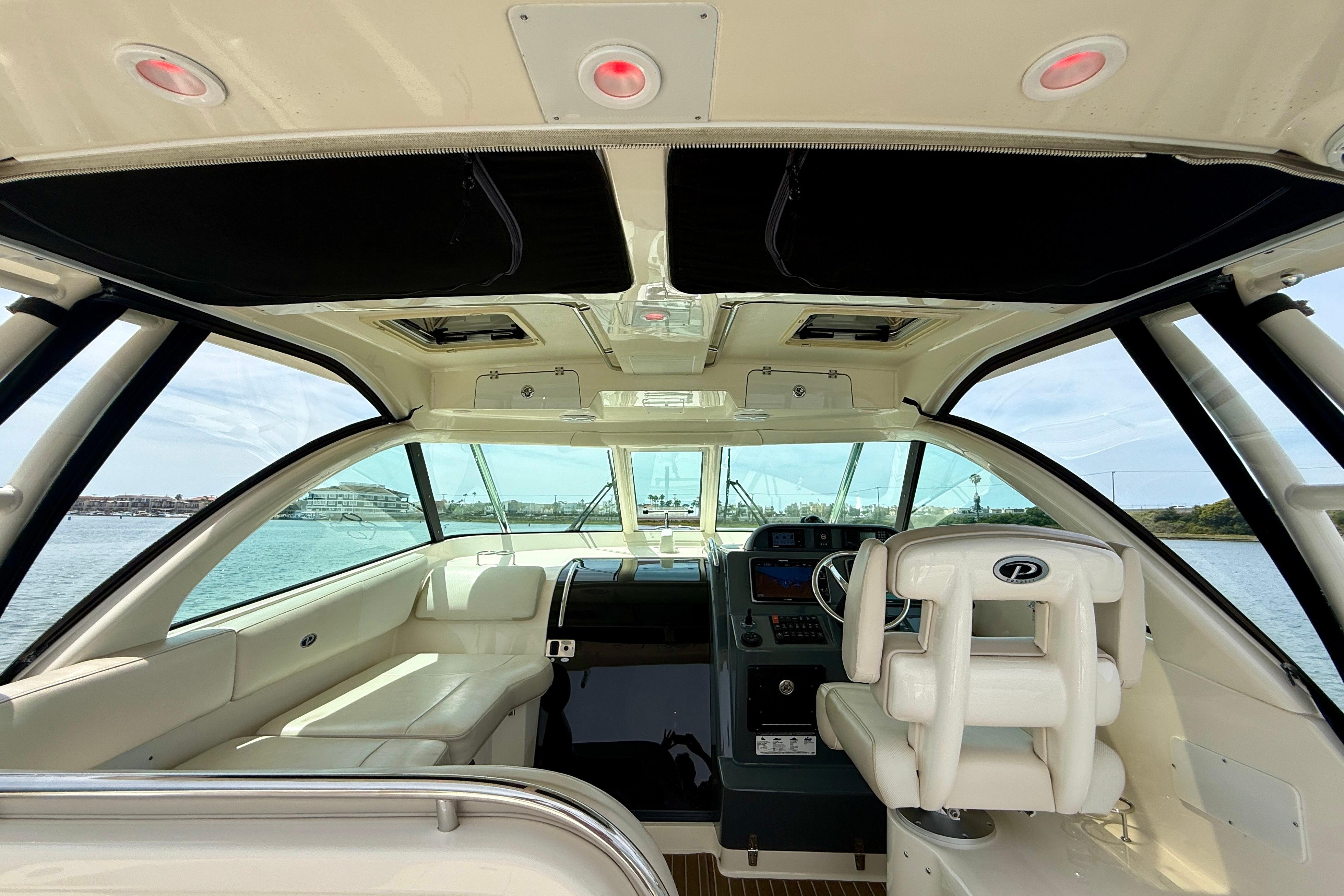 Interior view of 2012 Pursuit OS 345 Offshore boat, featuring helm and seating area.