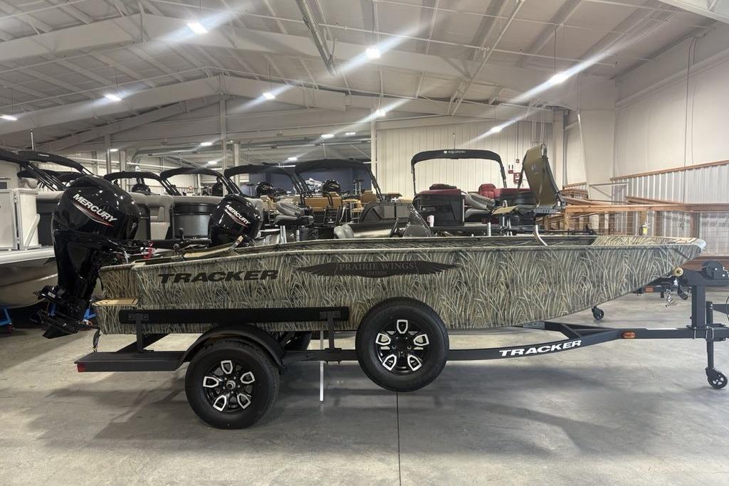 2026 Tracker Grizzly 1650 T Prairie Wings Edition boat in showroom, side view.
