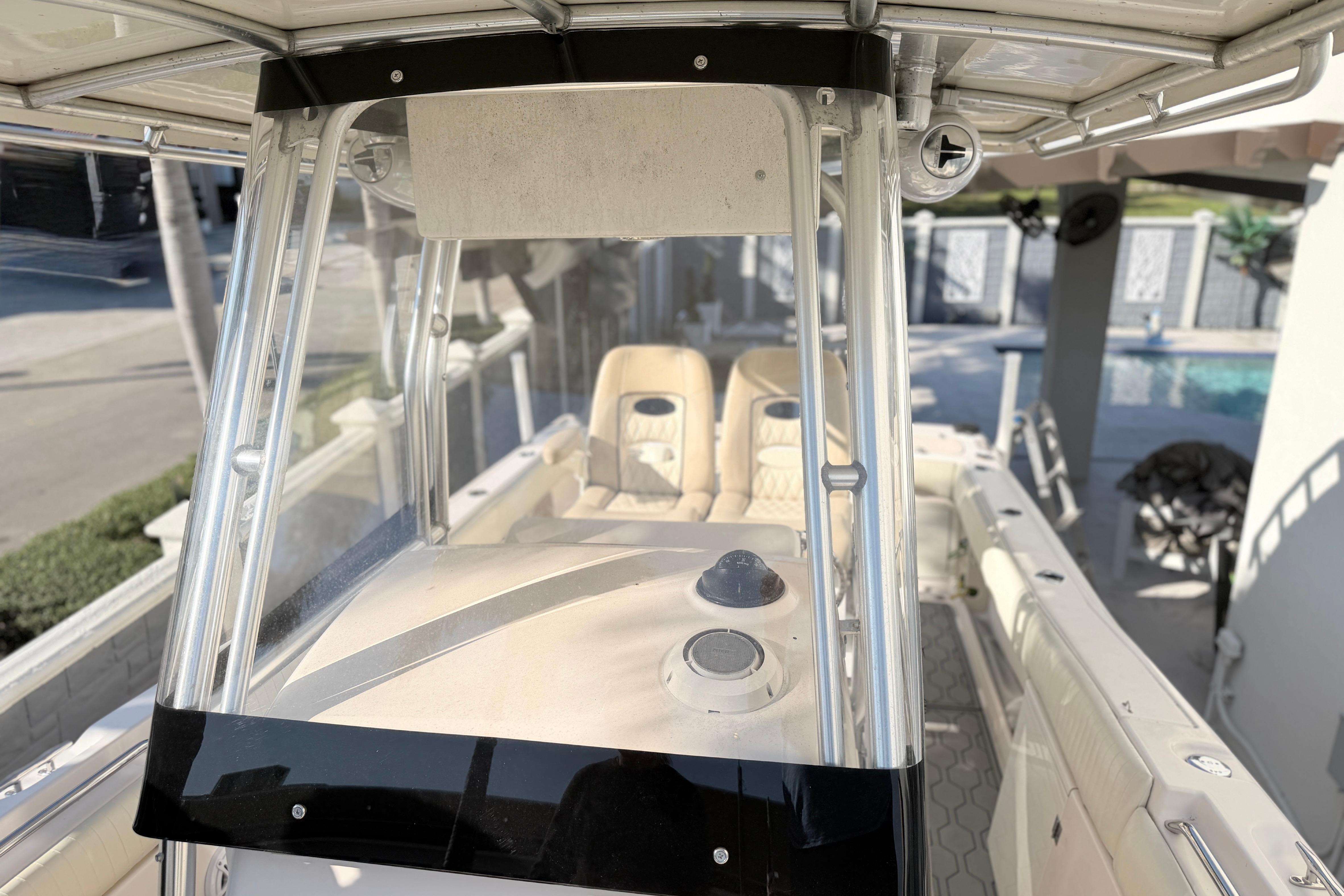 2004 Grady White 273 boat interior with seating and console, docked near a pool.