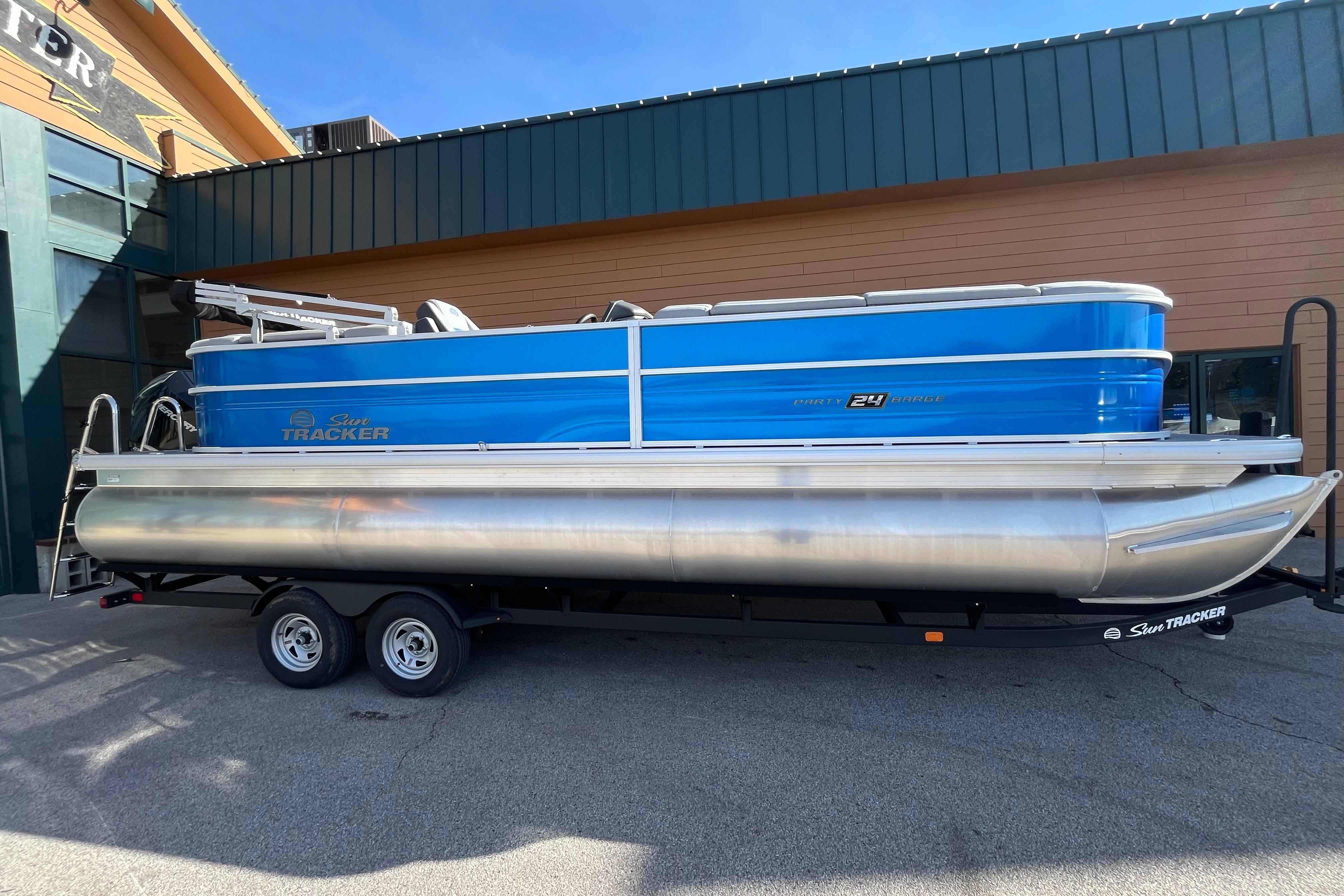 2026 Sun Tracker Party Barge 24 XP3 pontoon boat on trailer, parked outdoors.