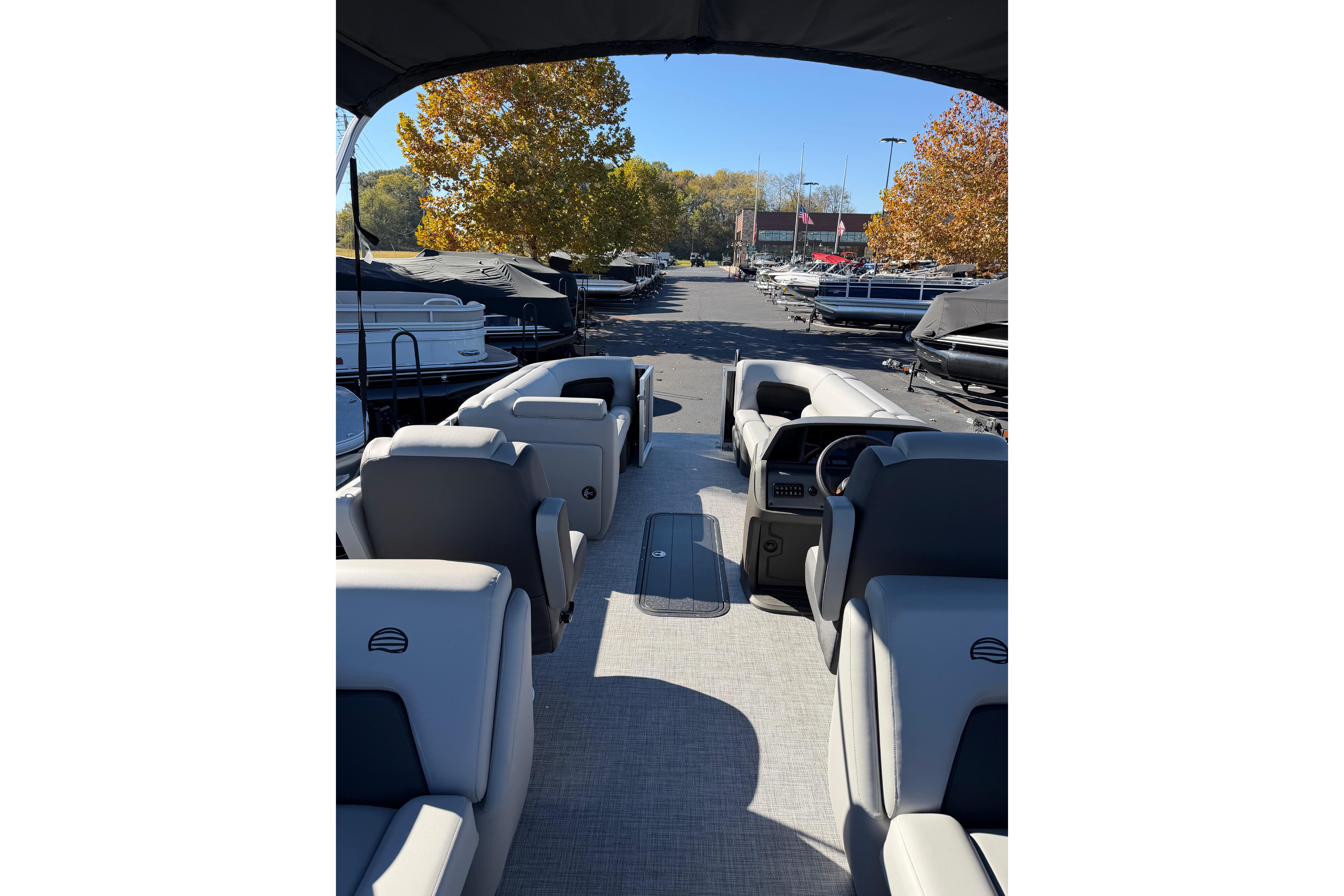 2026 Sun Tracker Party Barge 22 XP3 interior with seating and helm, parked outdoors.