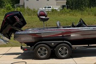 A 2024 Triton Trx19 Patriot boat on a trailer, featuring a powerful outboard motor.