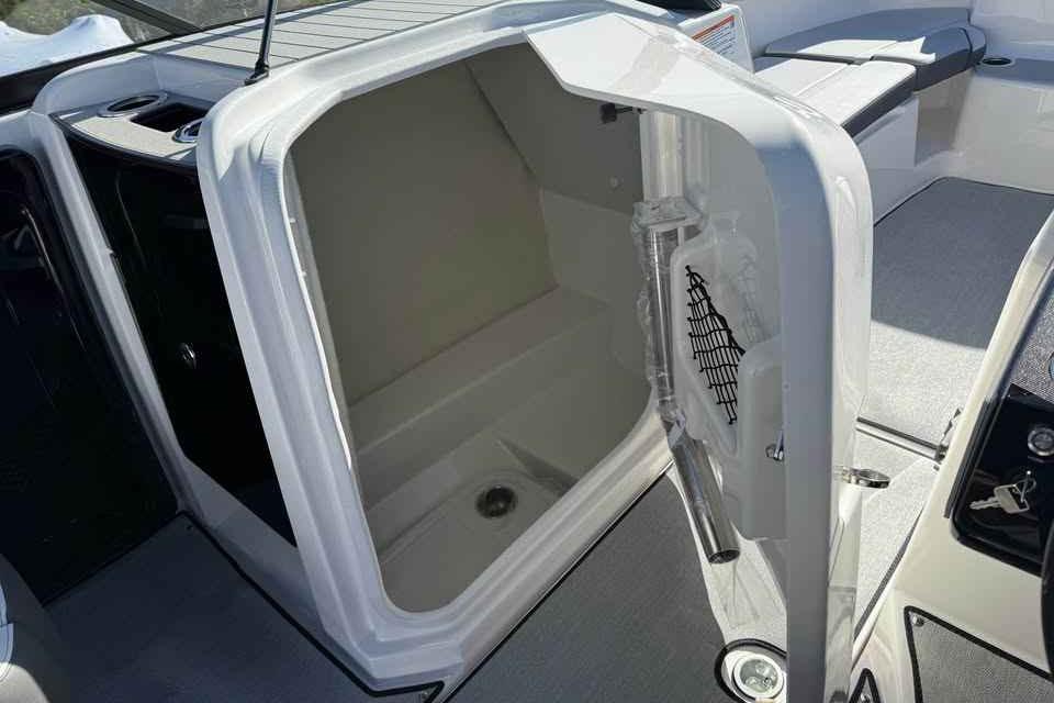 2026 Yamaha Boats AR250 interior storage compartment with open door, showcasing spacious design.