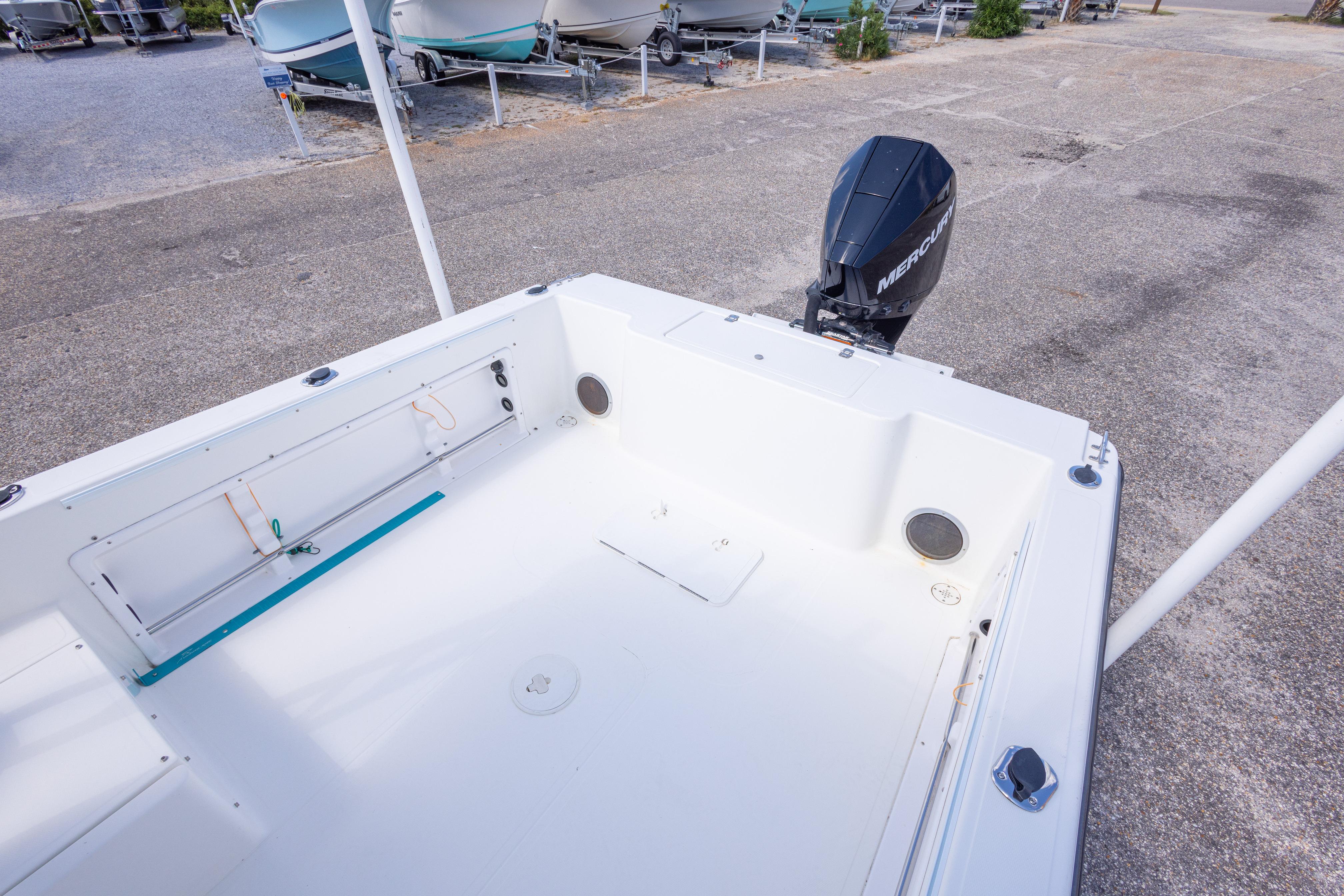 2007 Sea Boss 235 Walkaround boat with Mercury outboard engine, docked on concrete.