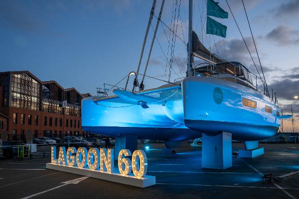 2025 Lagoon 60 yacht illuminated at dusk, showcasing sleek design and modern architecture.