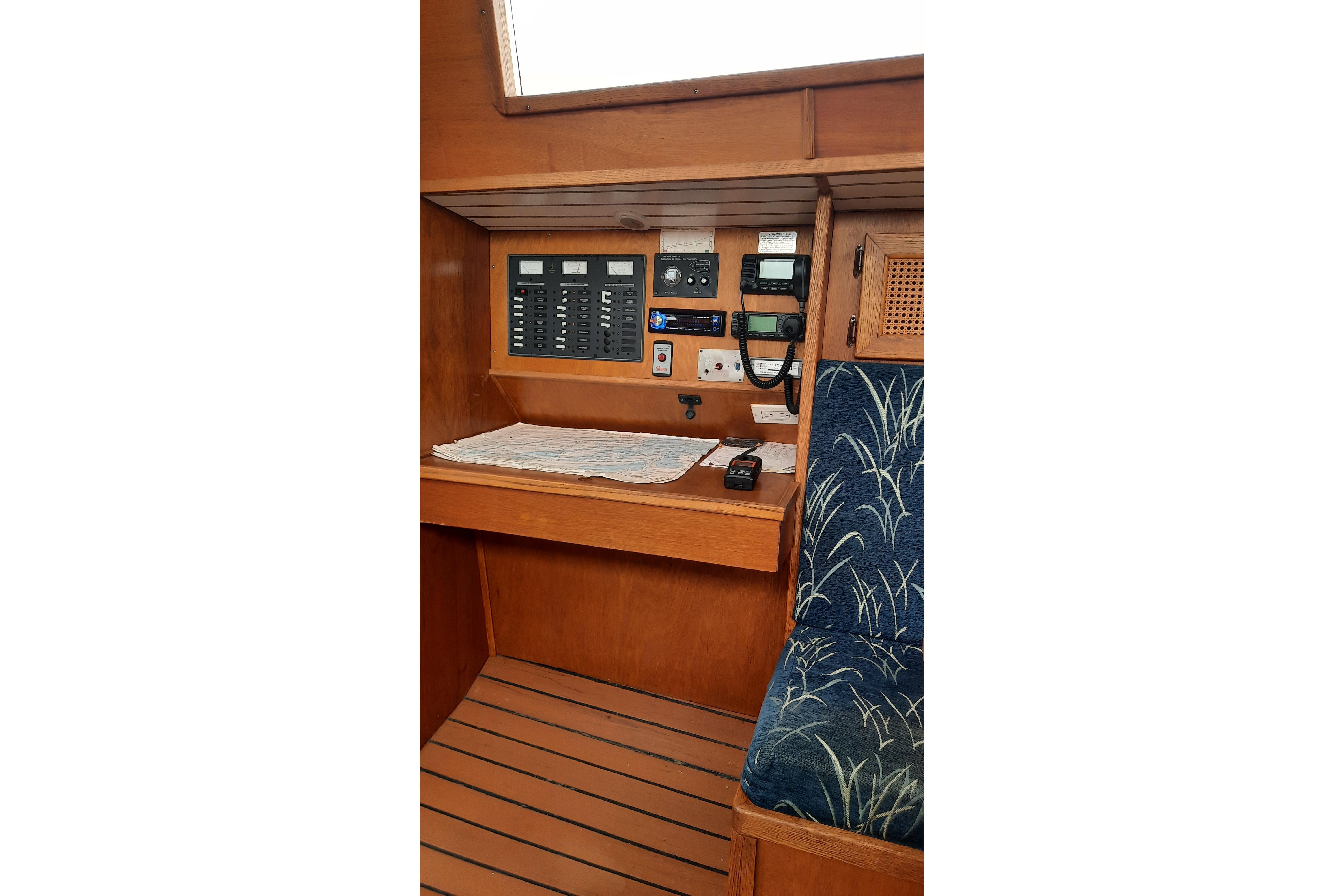 Interior of 2005 Bruce Roberts 38 sailboat with navigation panel and seating area.