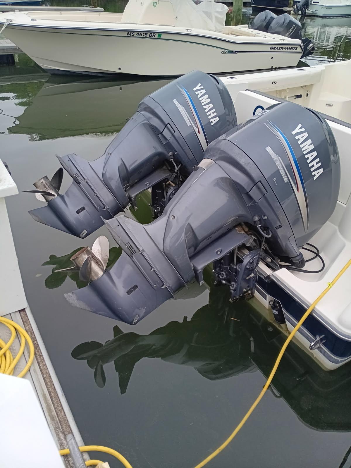Twin Yamaha outboard motors on a 2009 Pursuit 310 OS boat, docked in a marina.