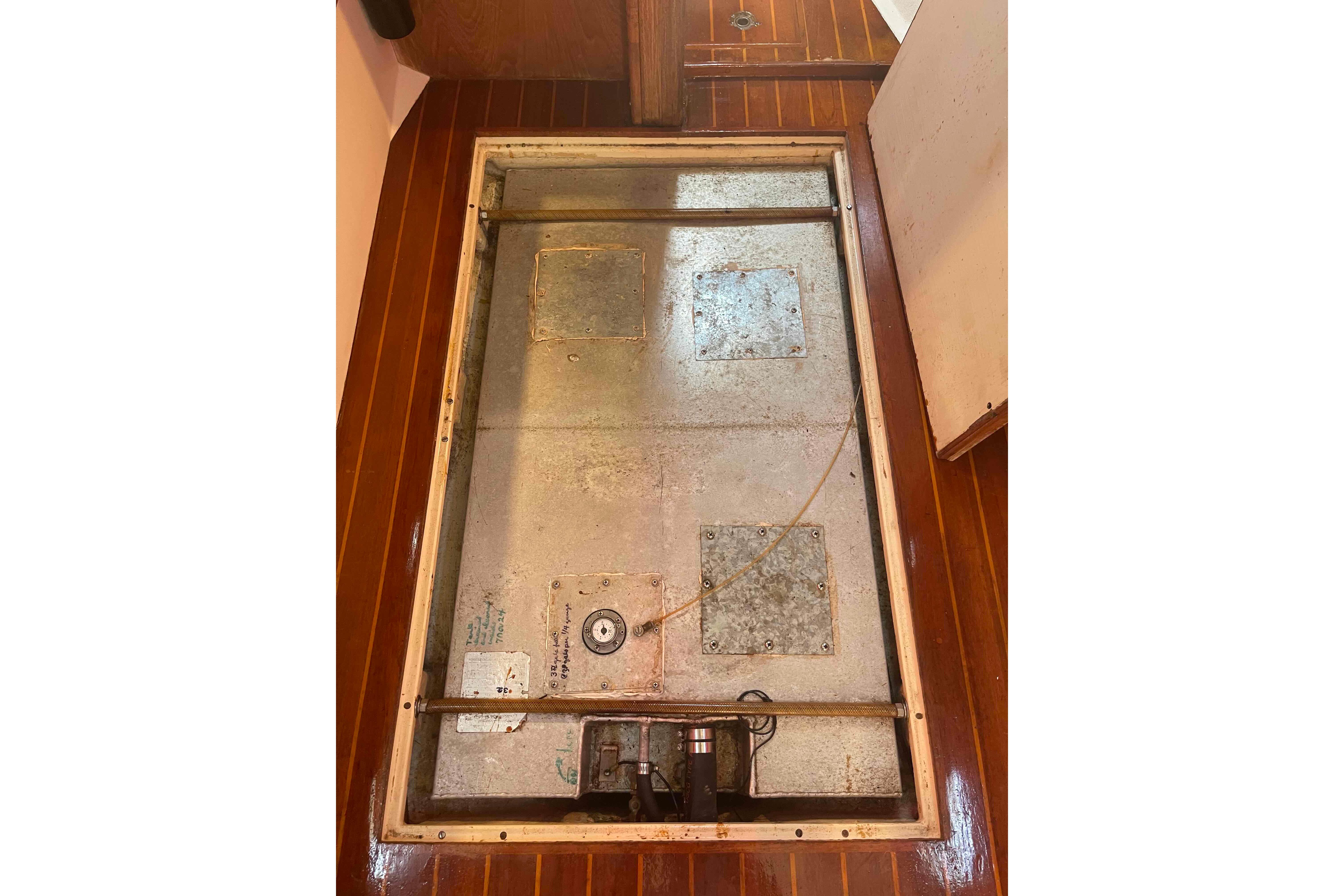 Bilge compartment of 1987 Pacific Seacraft 34 sailboat with wooden flooring.