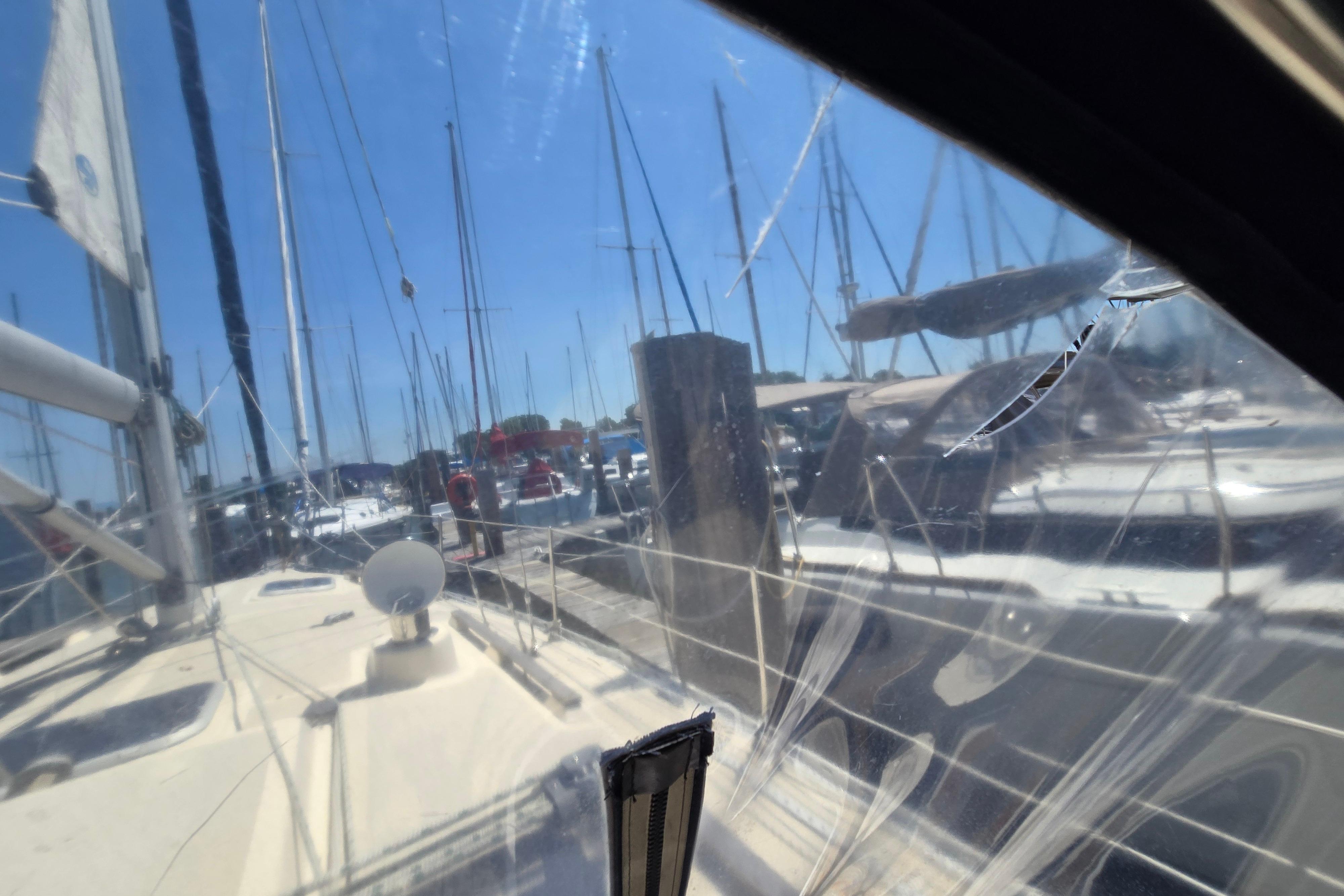 1993 Caliber 35 sailboat docked in marina, viewed through cracked window.