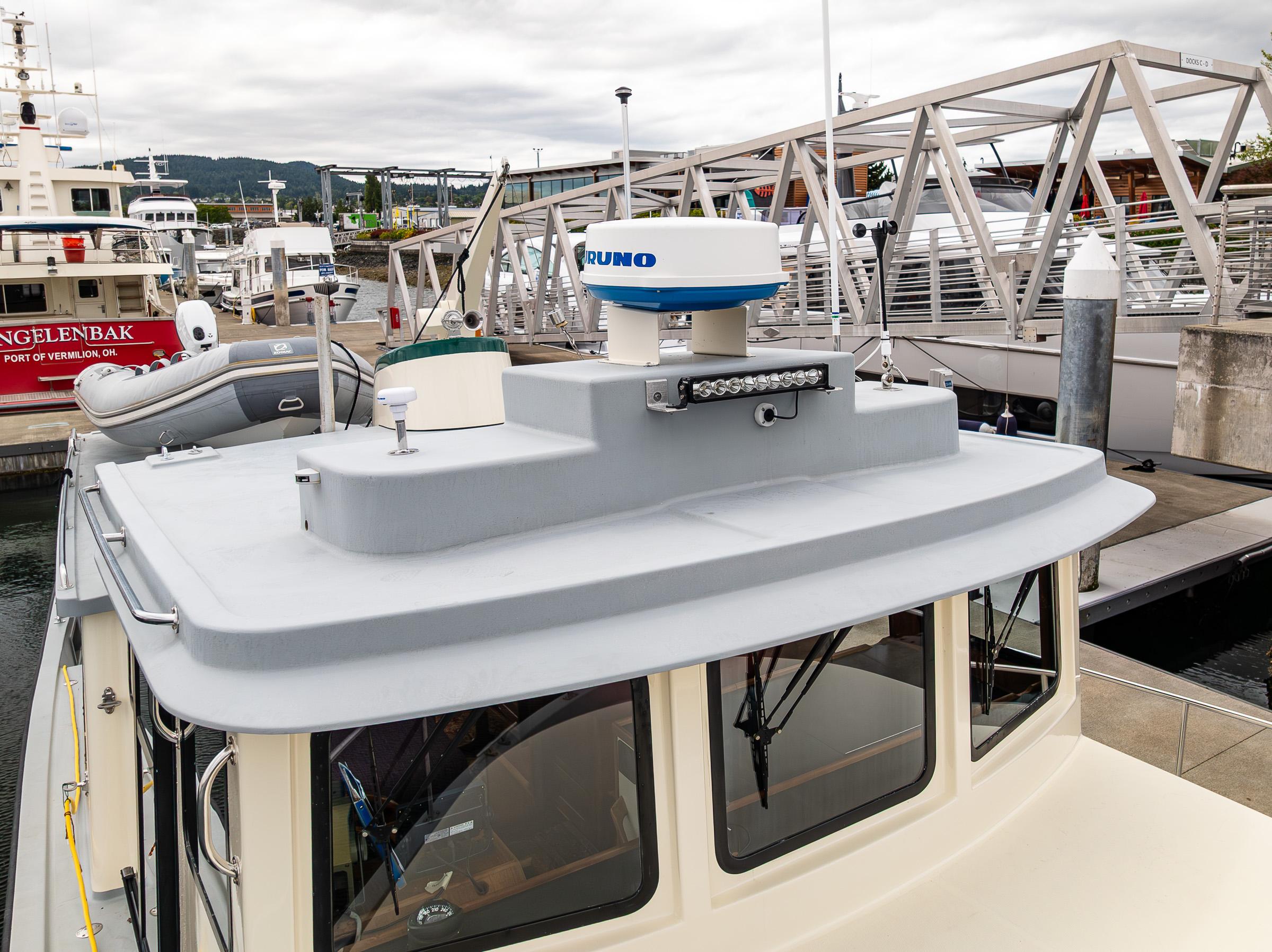 Nordic Tug 37 (2000) docked at marina, featuring radar and inflatable boat.