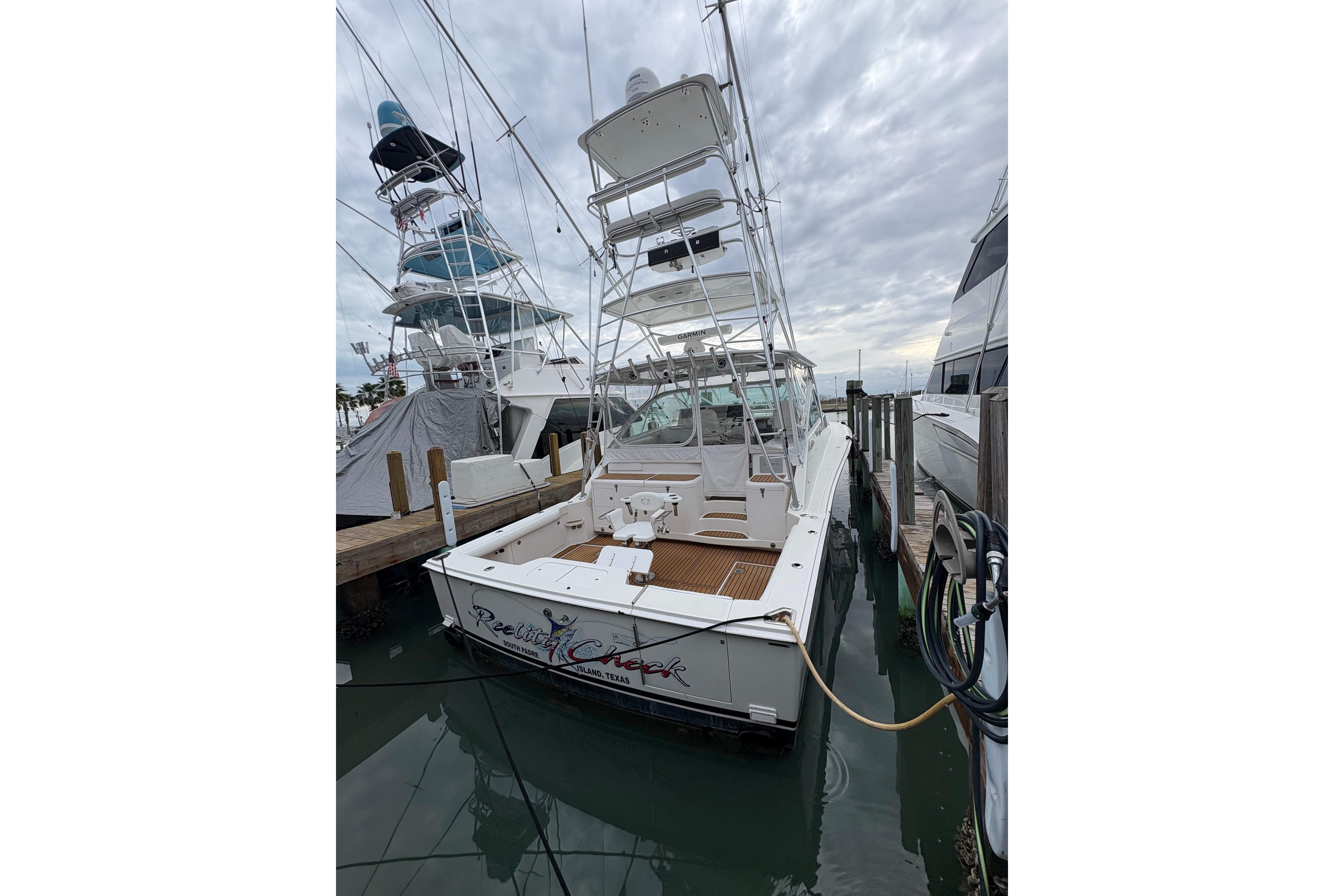 2004 Cabo 40 Hardtop Express docked, featuring a spacious deck and fishing tower.