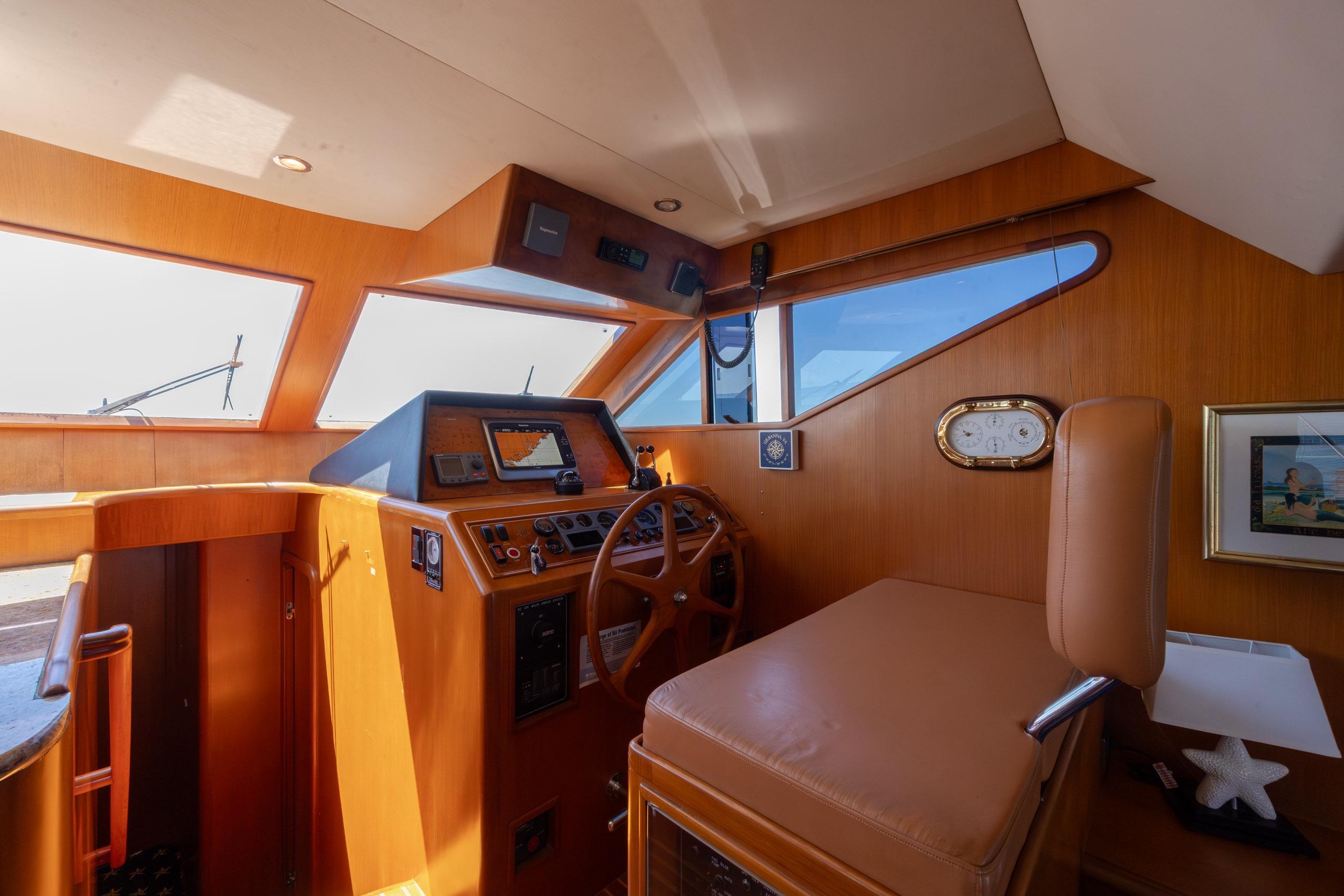 Interior helm of 2005 Ocean Alexander 52 Sedan yacht, featuring wood paneling and navigation equipment.
