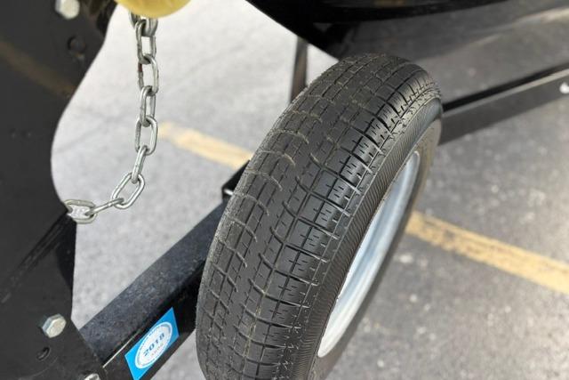 Trailer wheel of a 2017 Searay SPX210 boat, featuring a sturdy chain attachment.