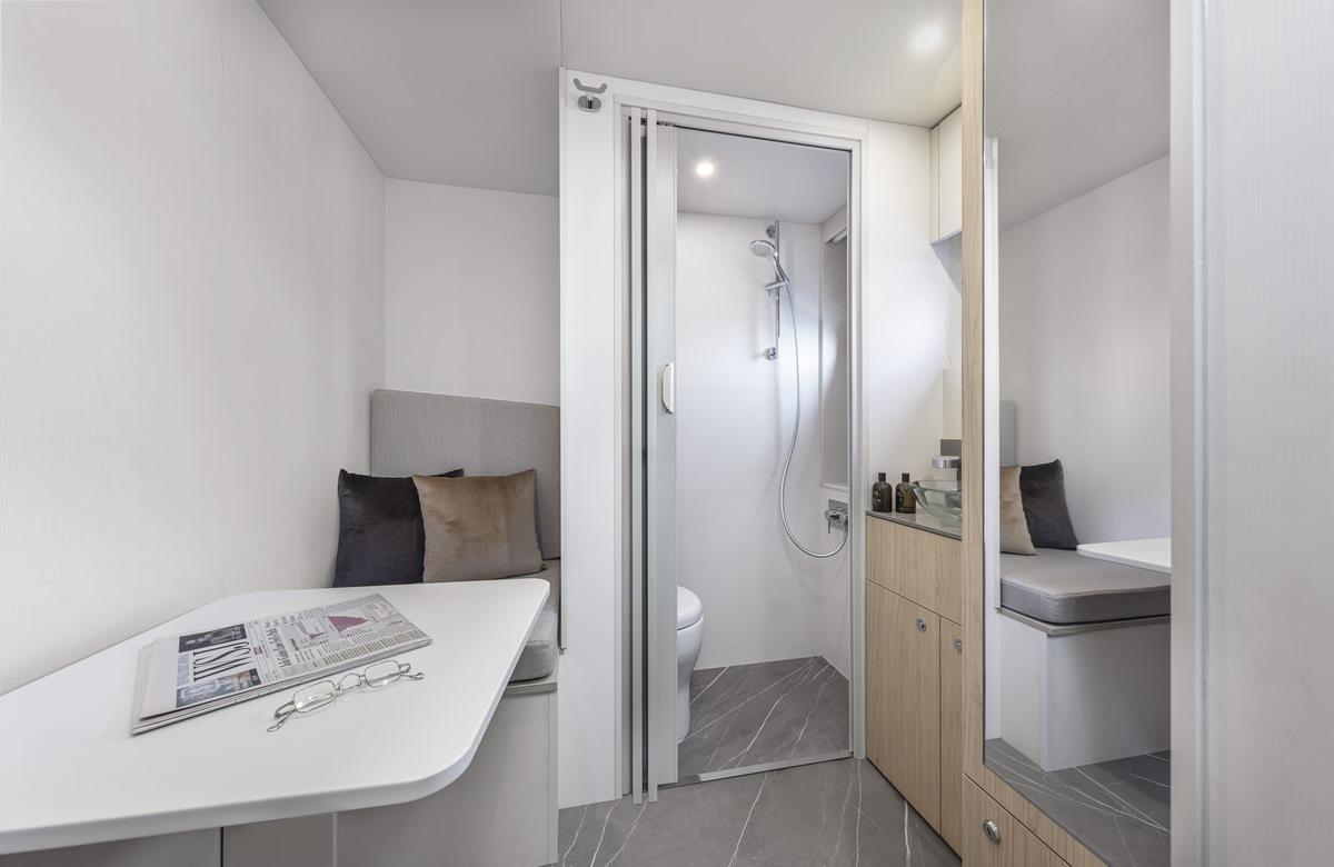 Luxurious interior of 2024 Absolute Navetta 64 yacht featuring a modern bathroom and seating area.