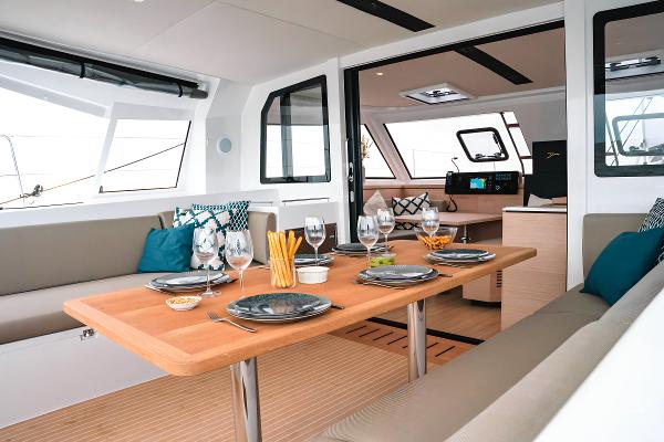 Luxurious interior of 2025 Nautitech 40 Open catamaran, featuring elegant dining setup and modern design.