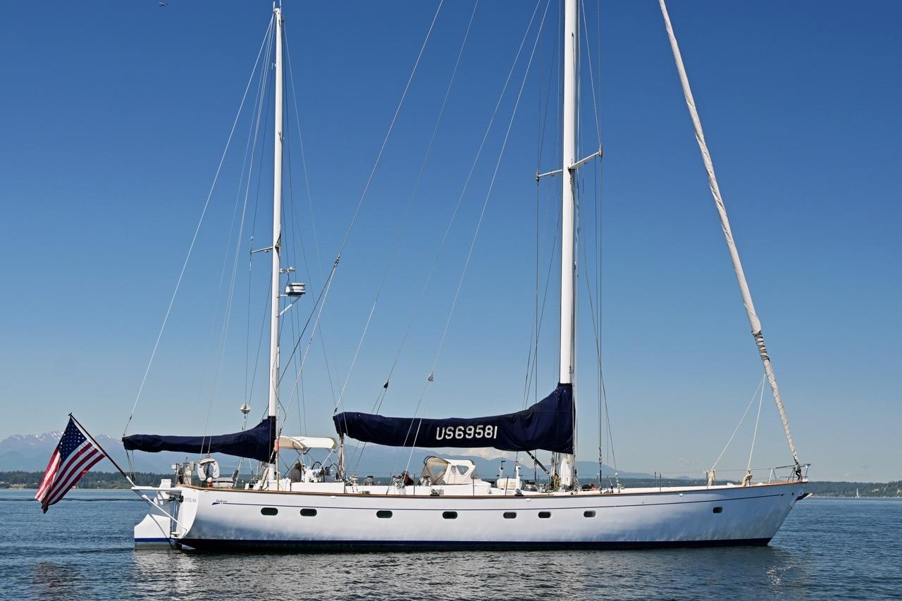 Sailing yacht Abeking & Rasmussen Tripp 74, 1968 model, on calm waters with clear blue sky.