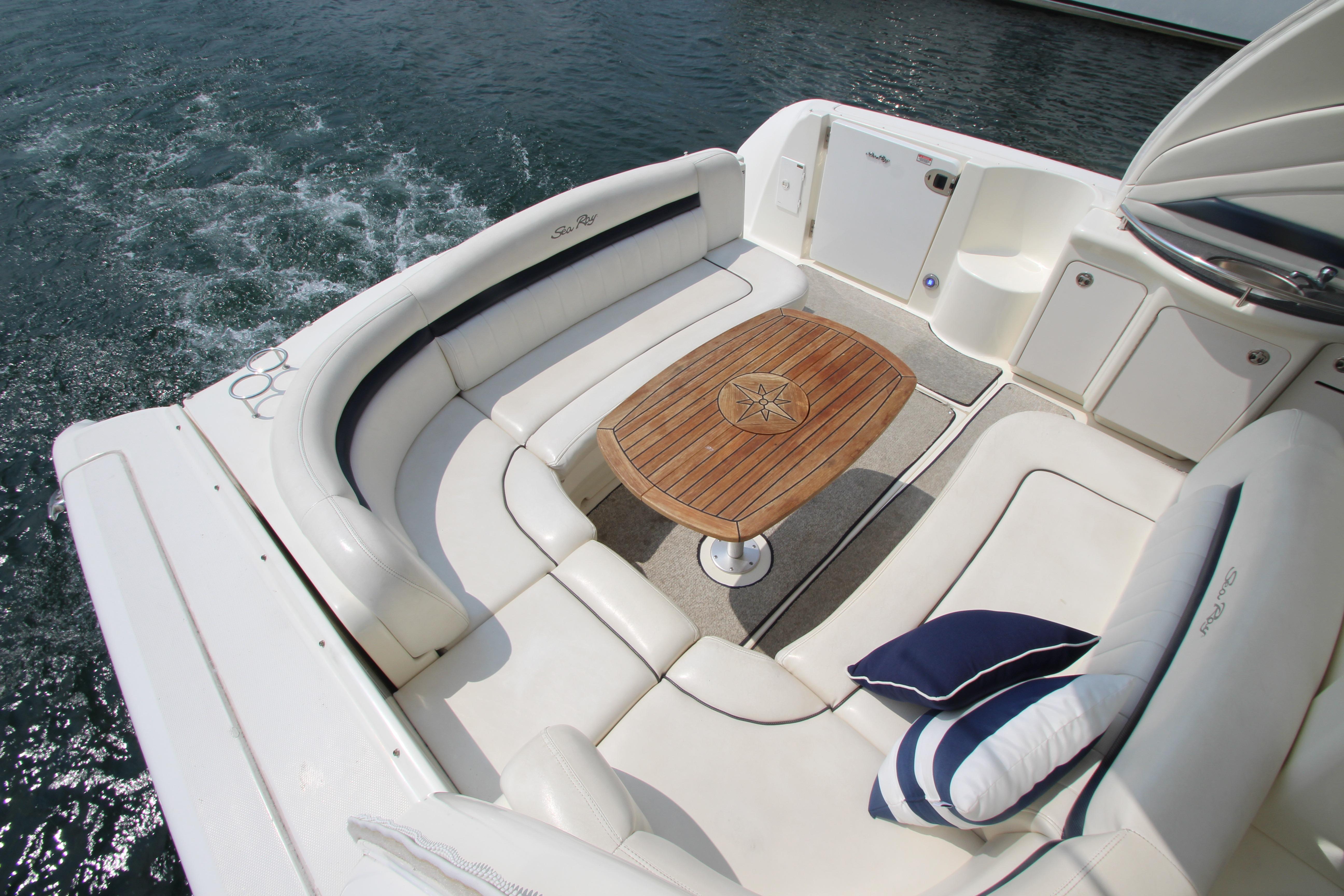 Luxurious 2004 Sea Ray 40 Sundancer yacht with elegant seating and wooden table on deck.