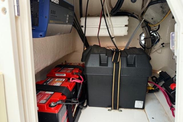 2016 Boston Whaler 150 Montauk boat battery compartment with secured batteries and wiring.