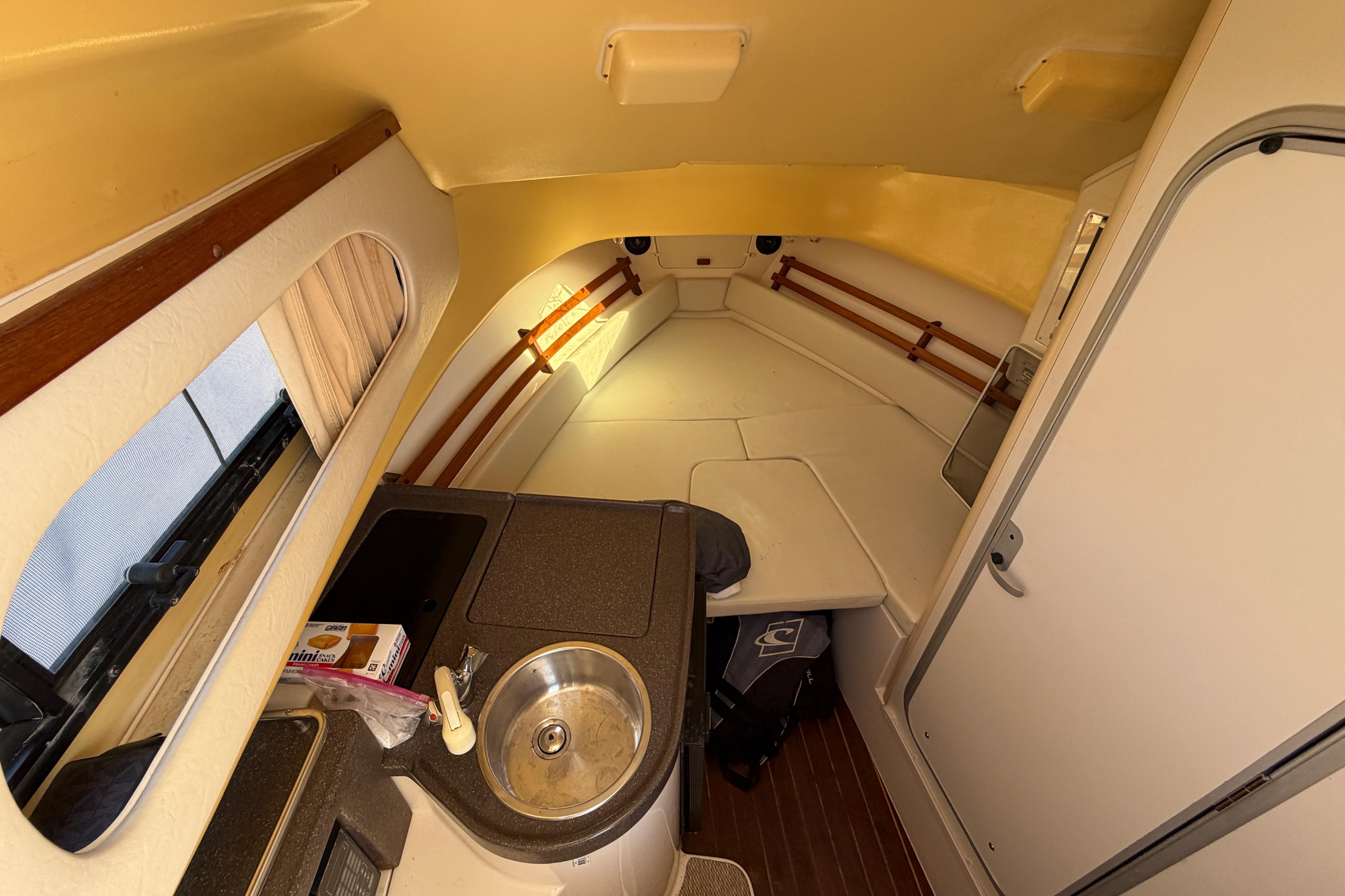 2006 Grady-White Sailfish 282 cabin interior with kitchenette and seating area.