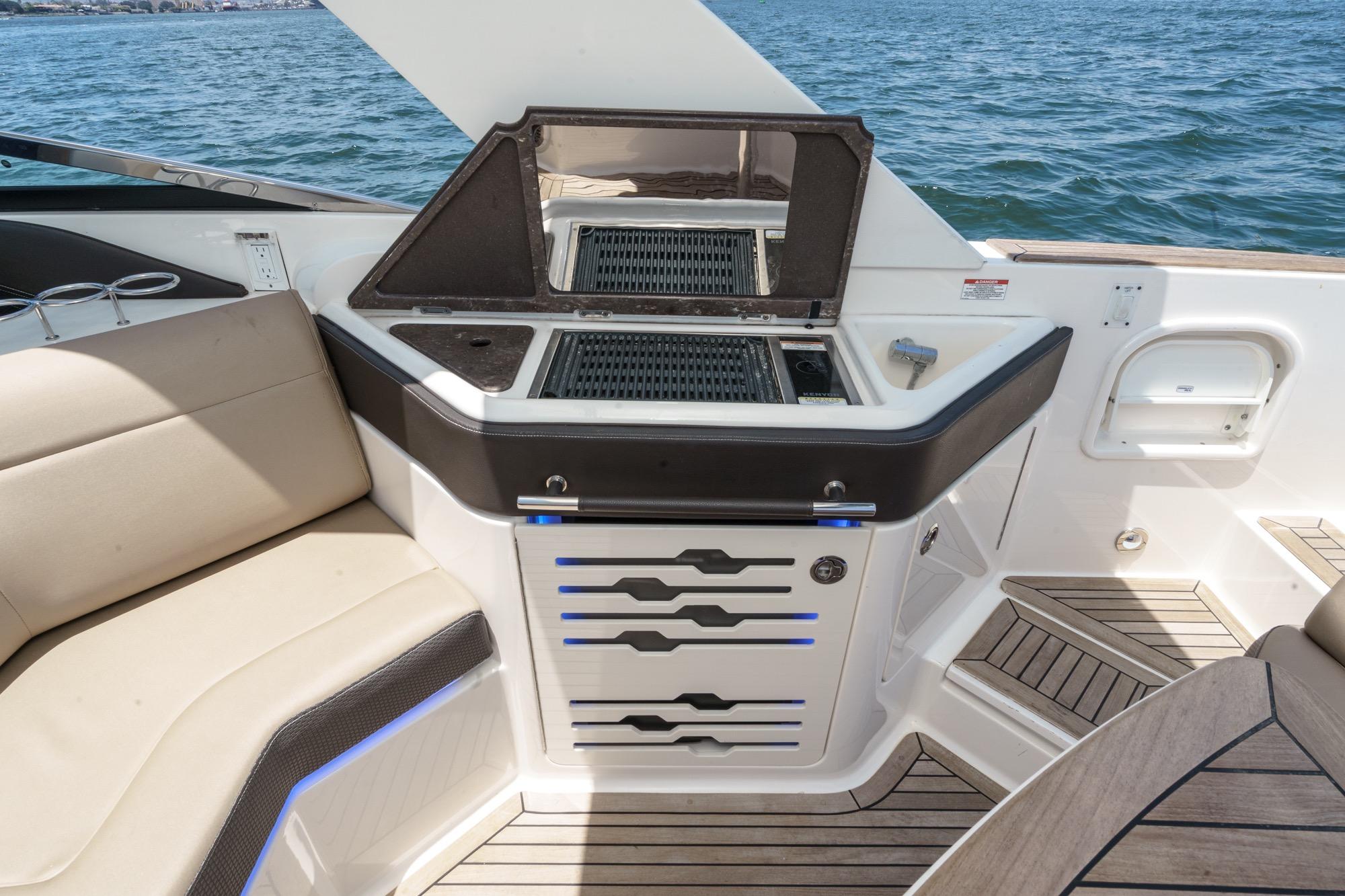 Luxurious 2018 Sea Ray SLX 310 boat interior with grill and seating area.