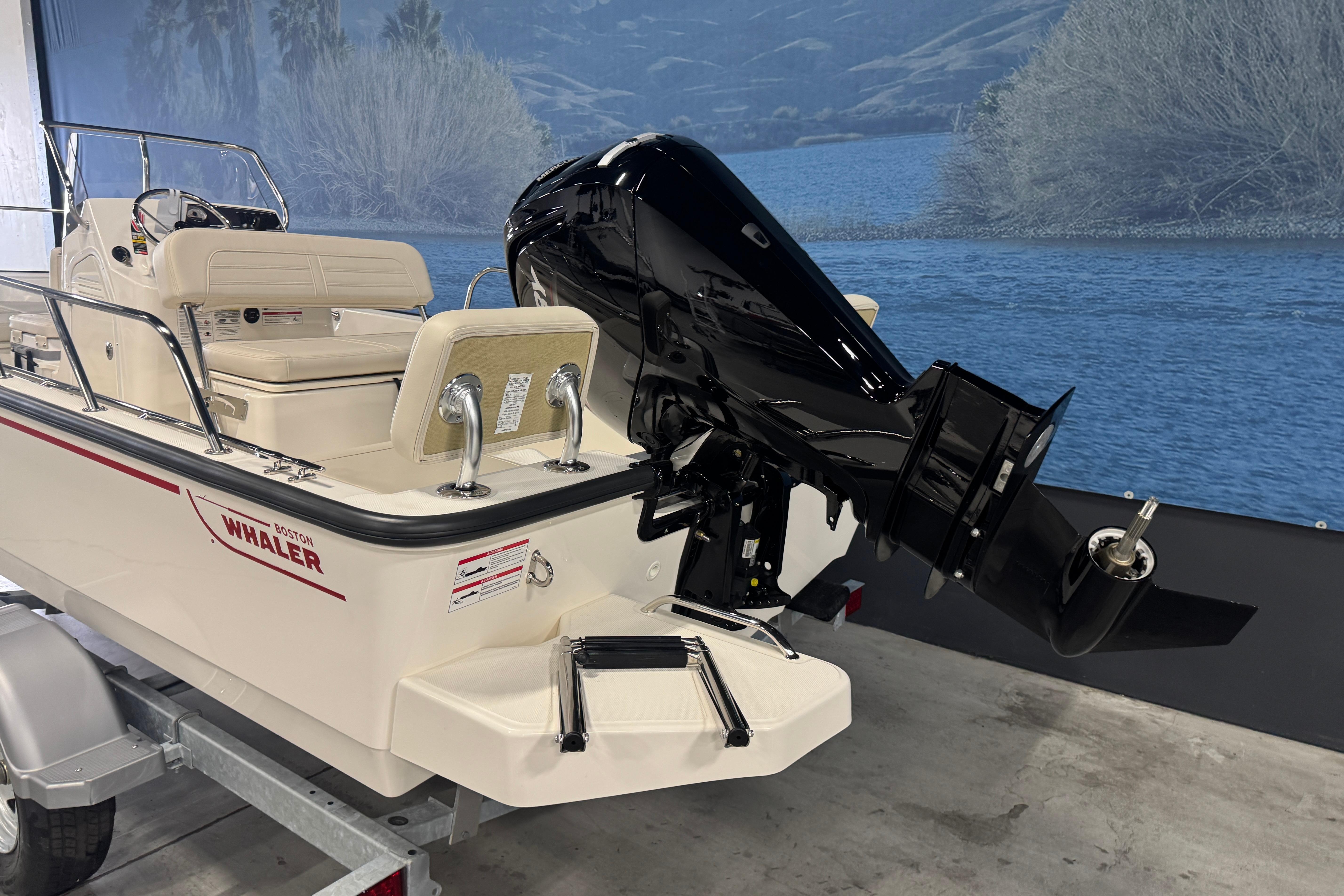 2026 Boston Whaler 170 Montauk boat with outboard motor, displayed indoors.