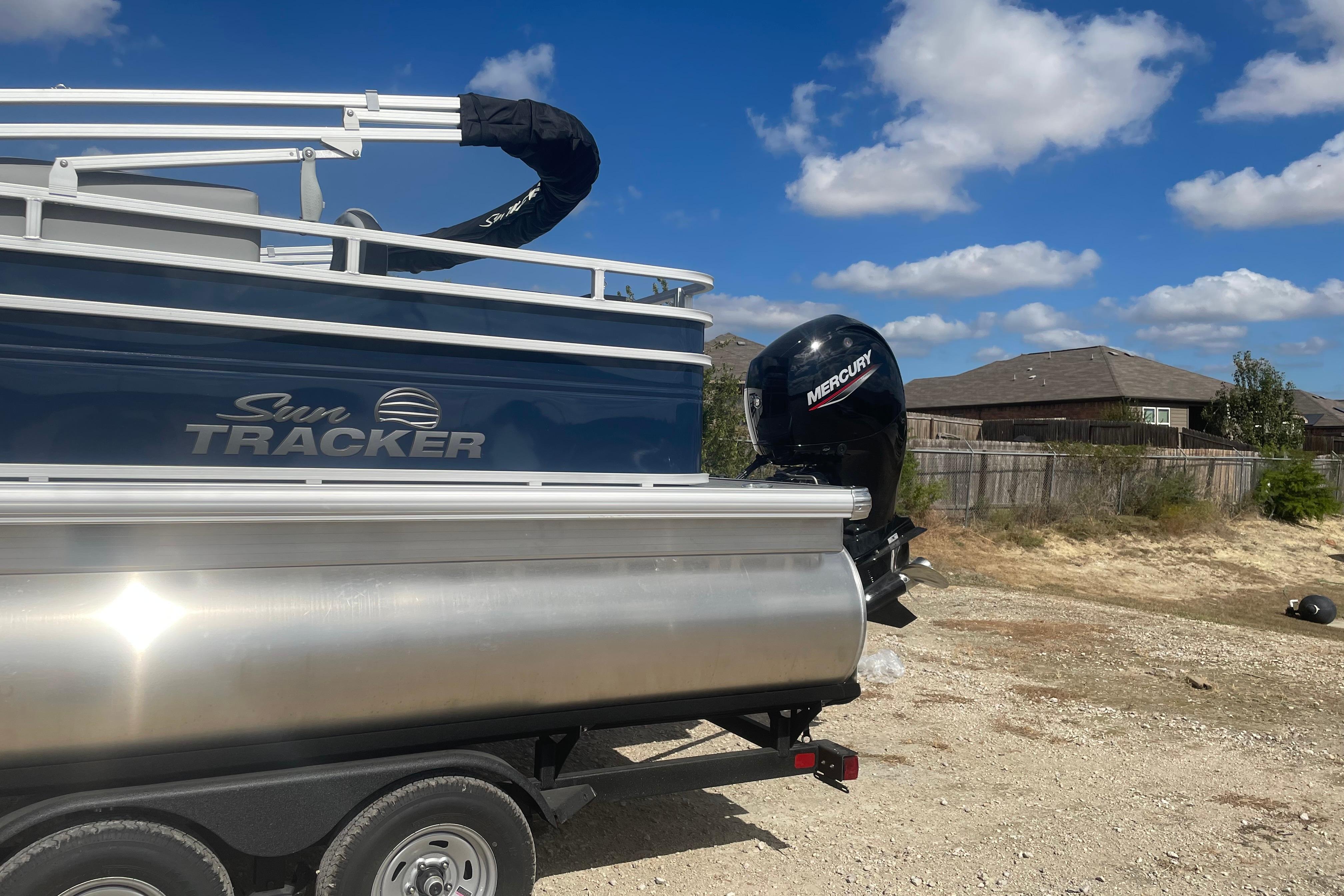 2026 Sun Tracker SportFish 22 DLX pontoon boat with Mercury engine on trailer.