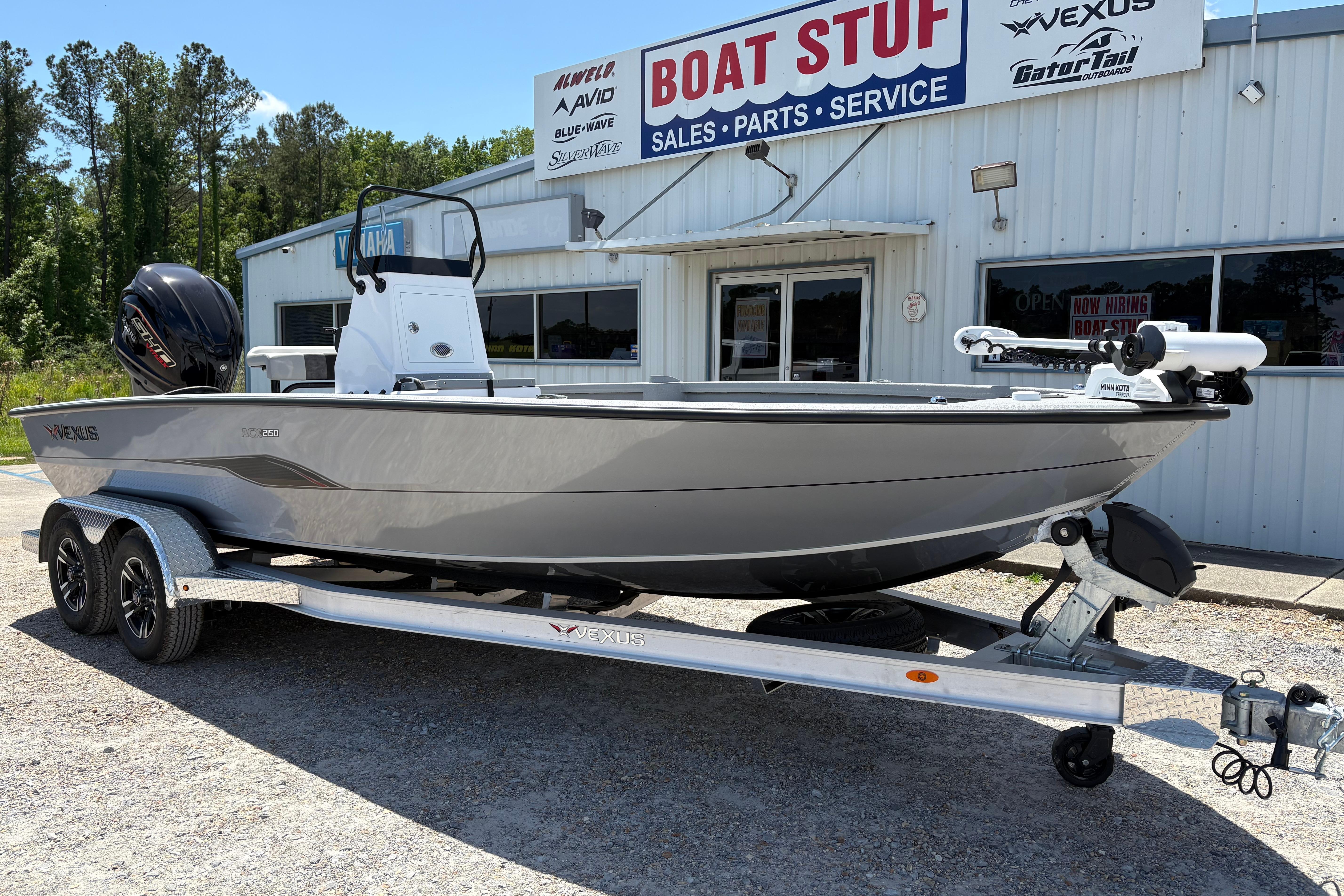 2026 Vexus ACX 2150 boat on trailer outside dealership, showcasing sleek design and modern features.