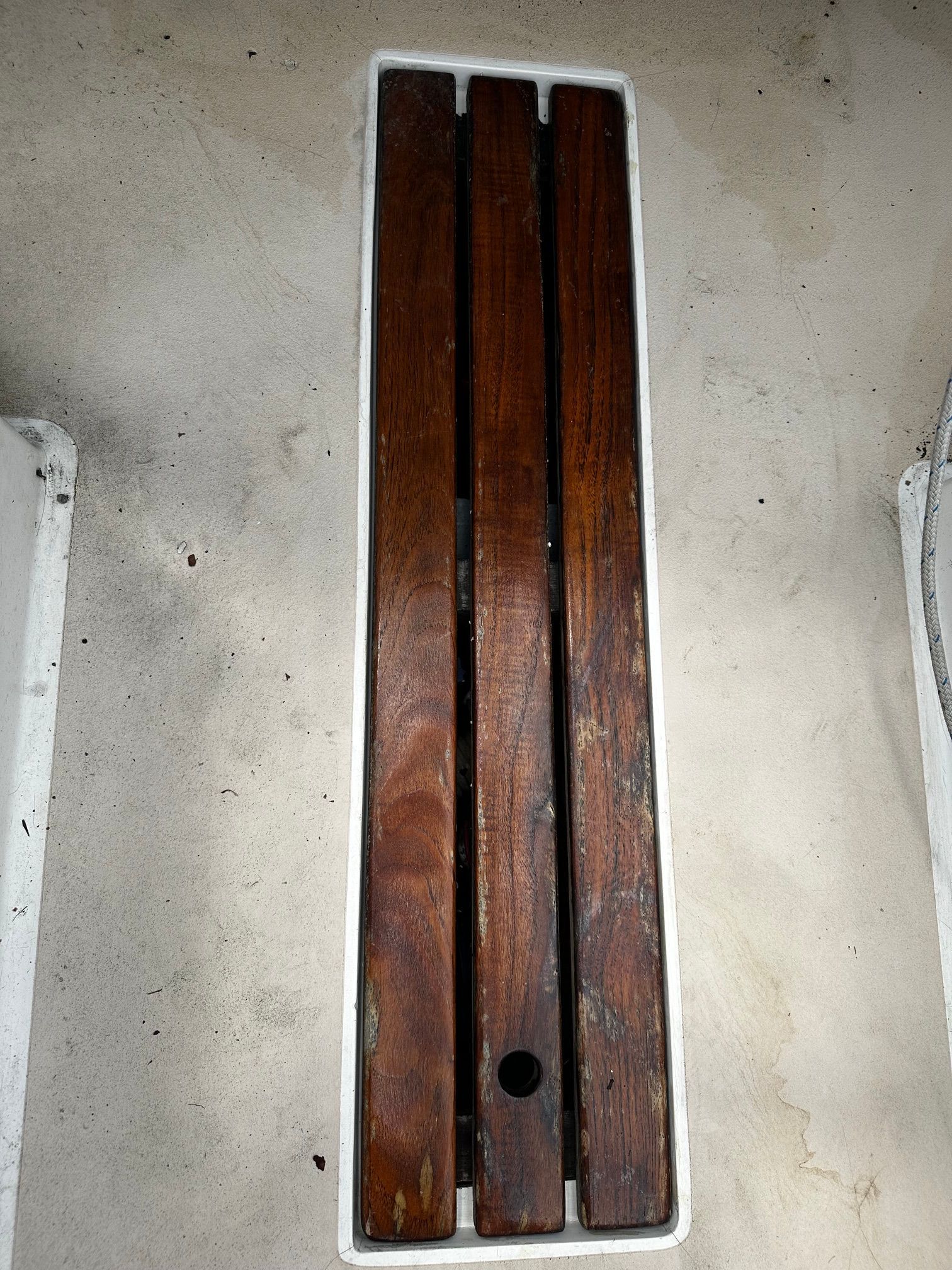 Wooden slats on a boat deck, surrounded by a white frame.