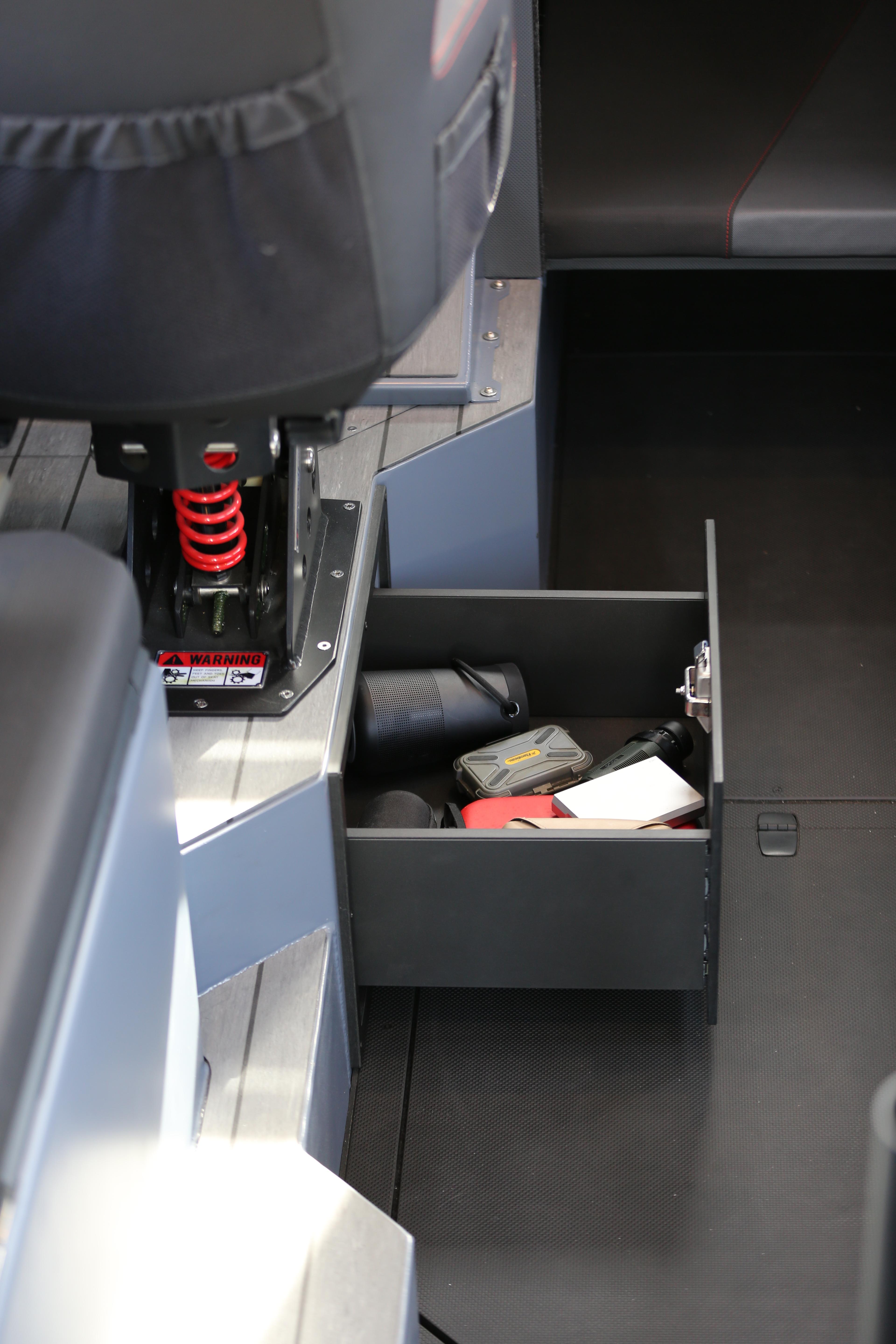 2026 Jaktar J30 Black Vision interior with open storage drawer and visible seat suspension.