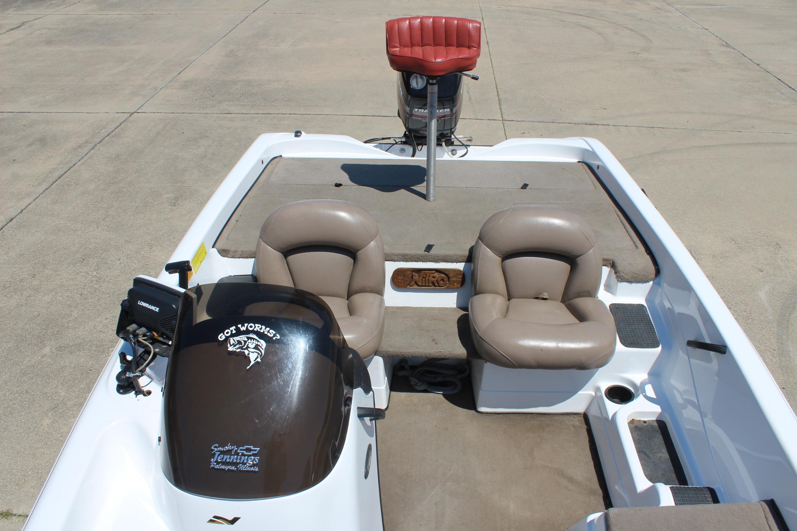 2003 Nitro NX 750 SC boat interior with seating and motor, parked on concrete.