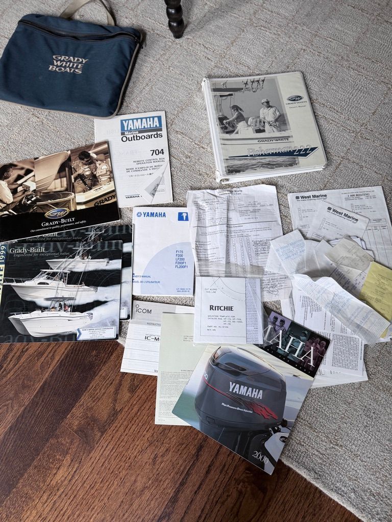 Grady-White Fisherman 222 boat documents and manuals on wooden floor.