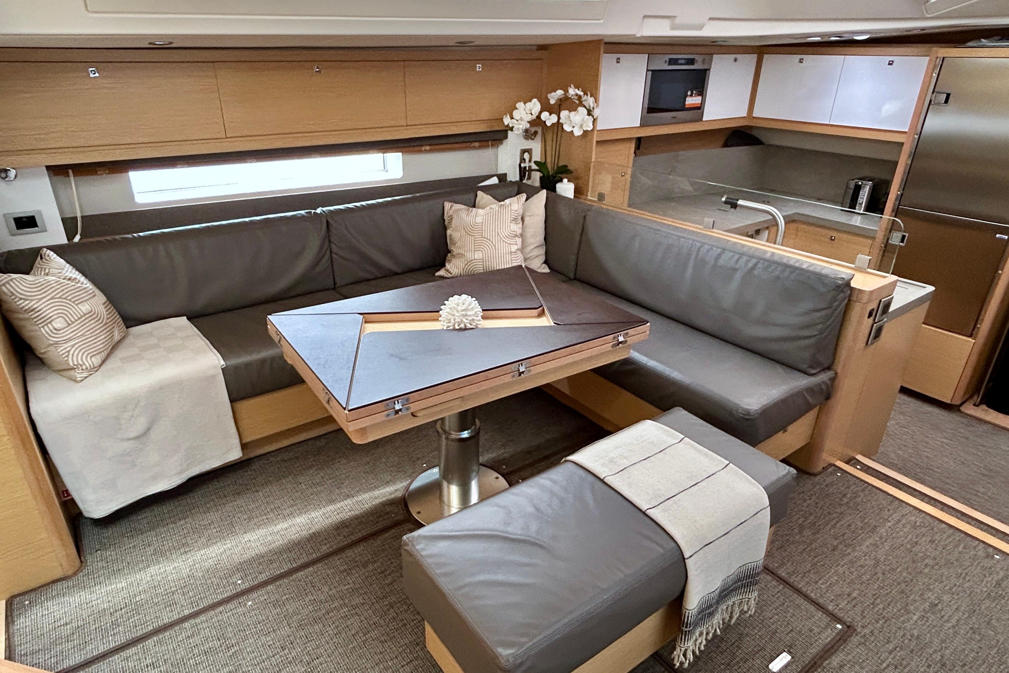 Luxurious interior of 2022 Dufour 61 yacht with modern seating and elegant decor.