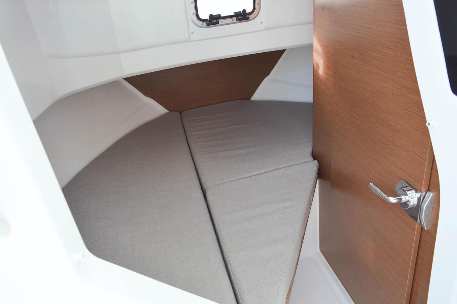 Manufacturer Provided Image: 2018 Jeanneau NC Sport 795 cabin interior with bed and wooden door.