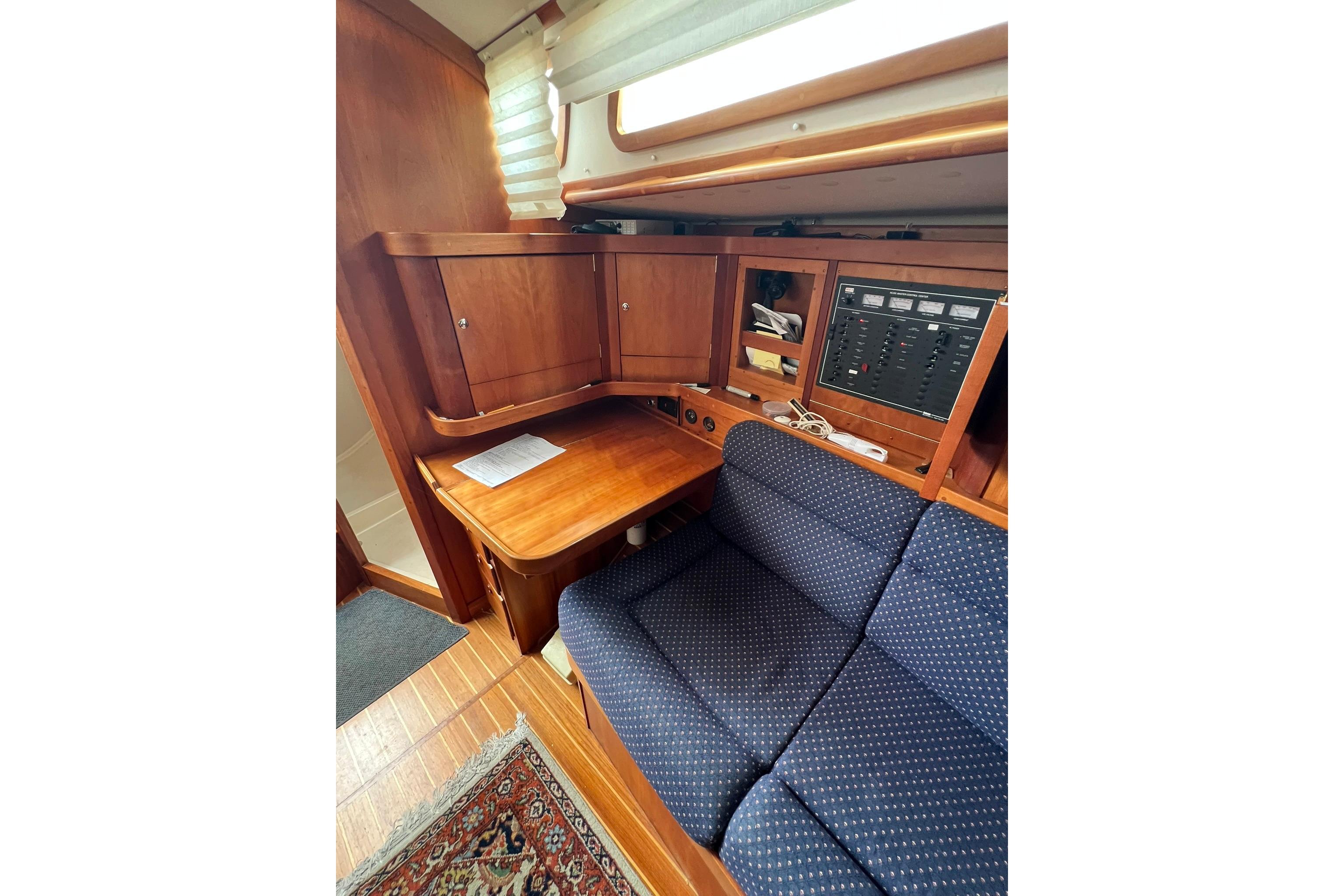 Interior of 1998 Sabre 362 yacht with wooden cabinetry and blue upholstered seating.