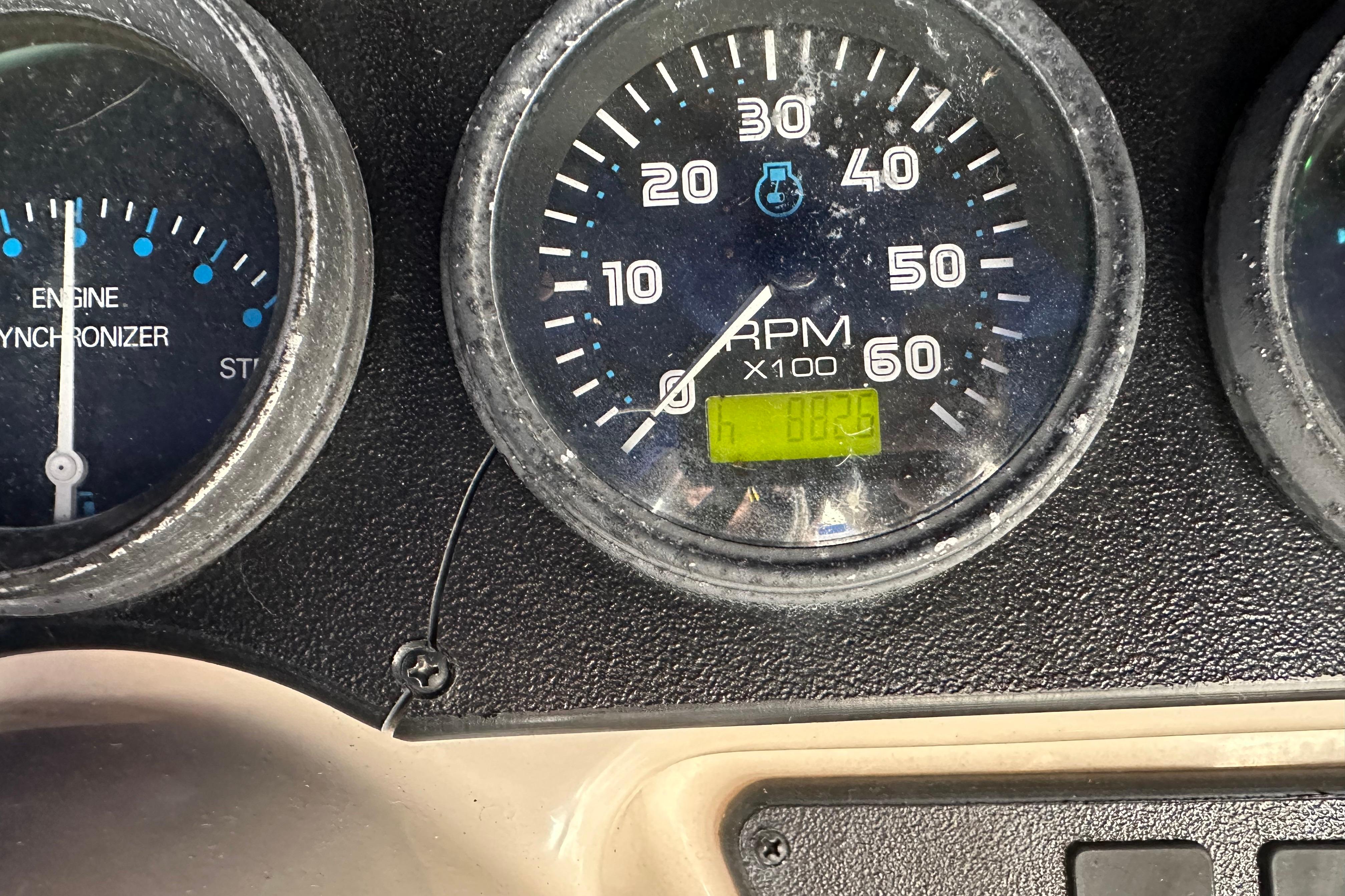 Close-up of 2005 Carver 36 Super Sport boat tachometer and engine synchronizer gauges.