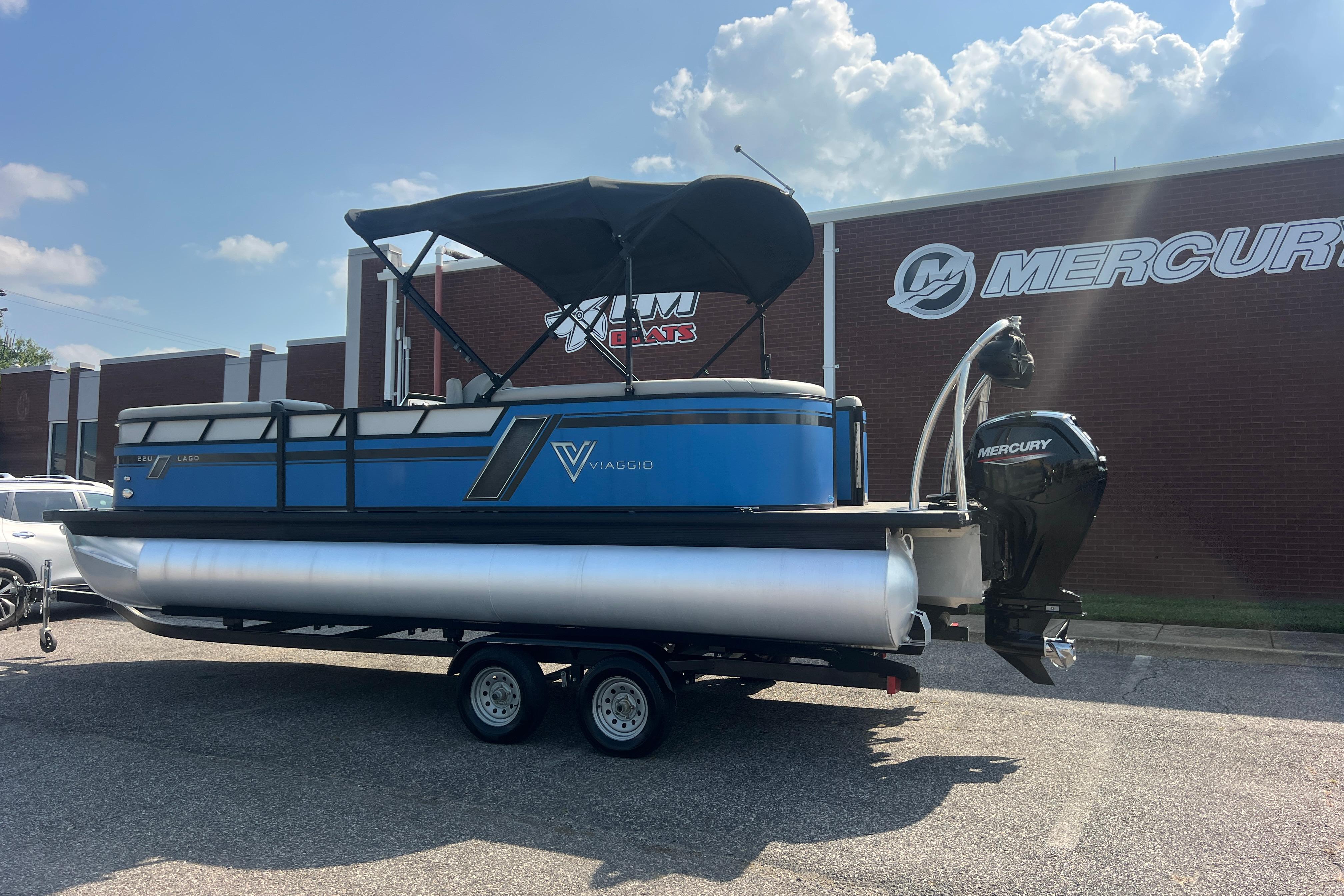 2022 Viaggio Lago V-U 22 pontoon boat with Mercury engine, parked outside dealership.