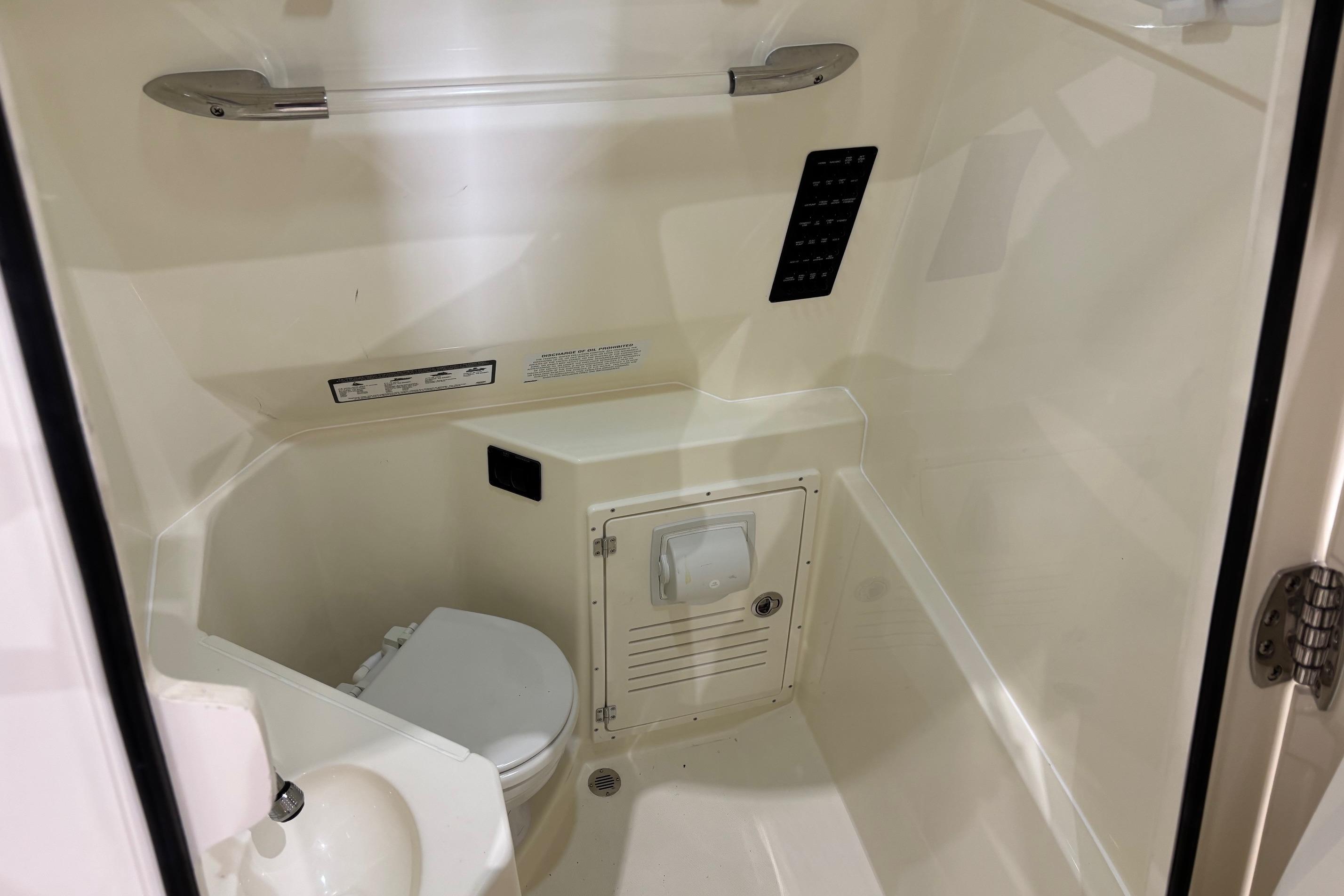 2026 Cobia 285 Open Center Console boat interior bathroom with toilet and sink.