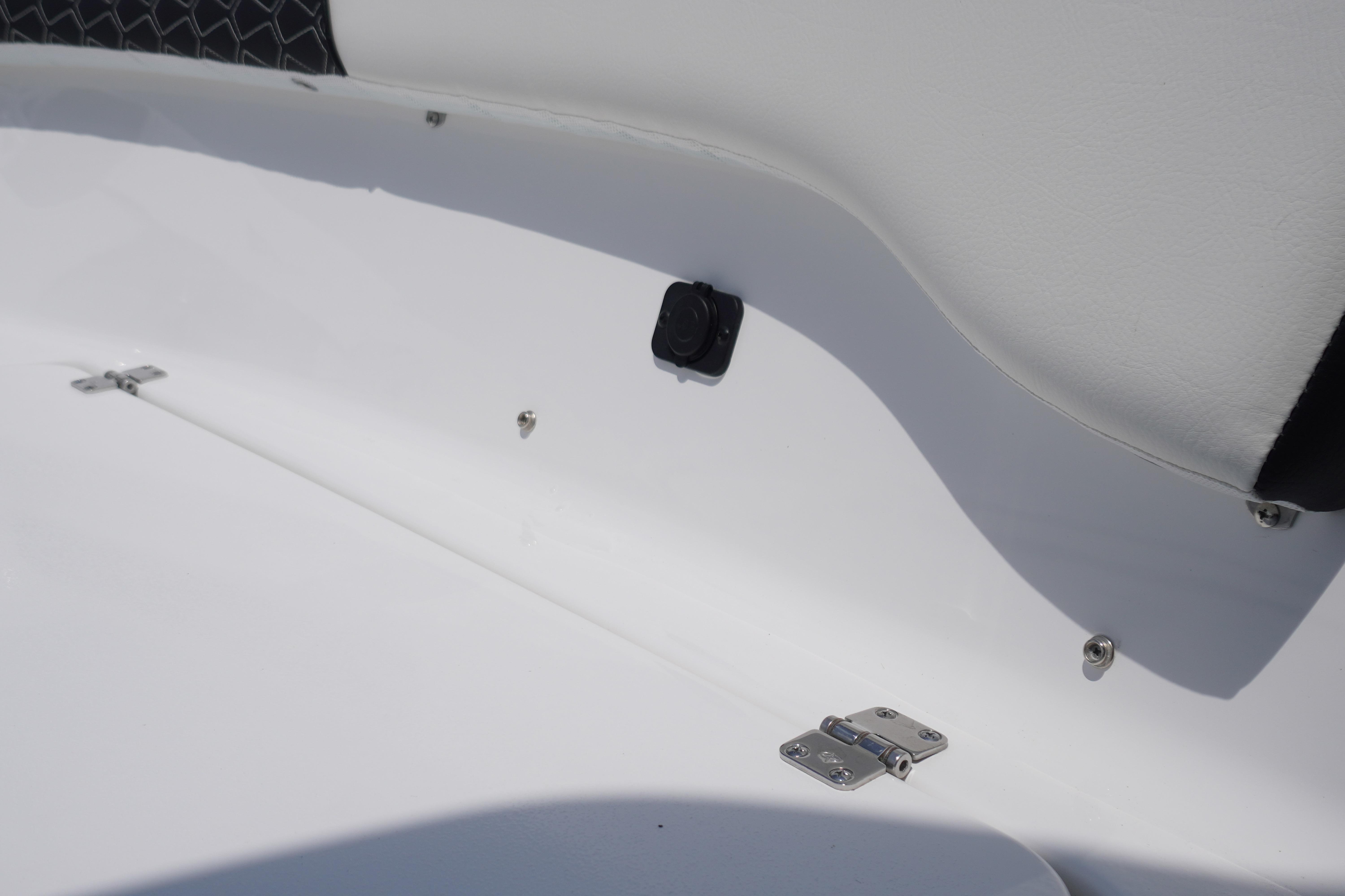 2027 Tidewater 220 CC Adventure boat interior detail with white upholstery and metal fittings.