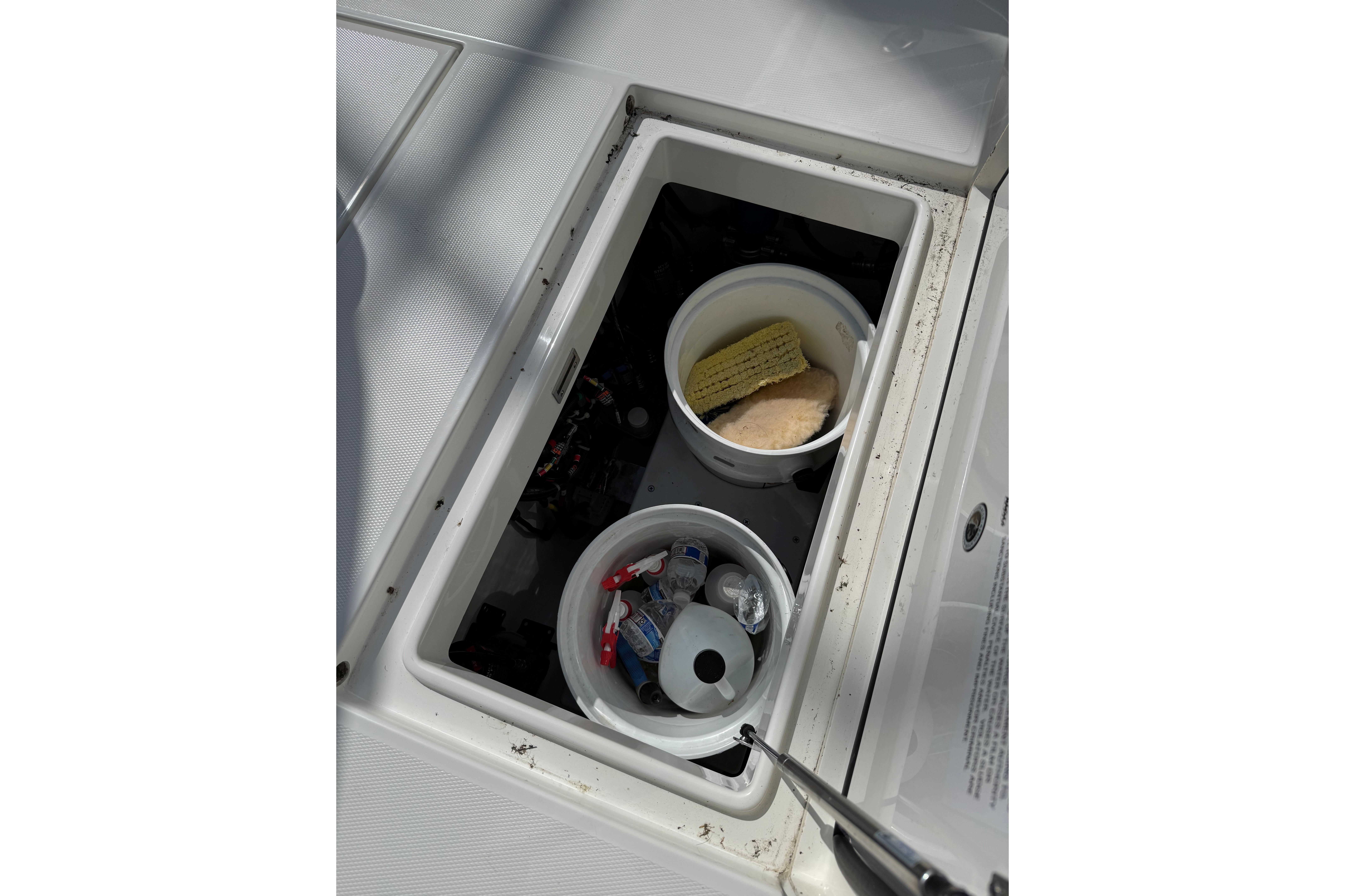 Storage compartment on a 2019 Regulator 34SS boat with cleaning supplies.