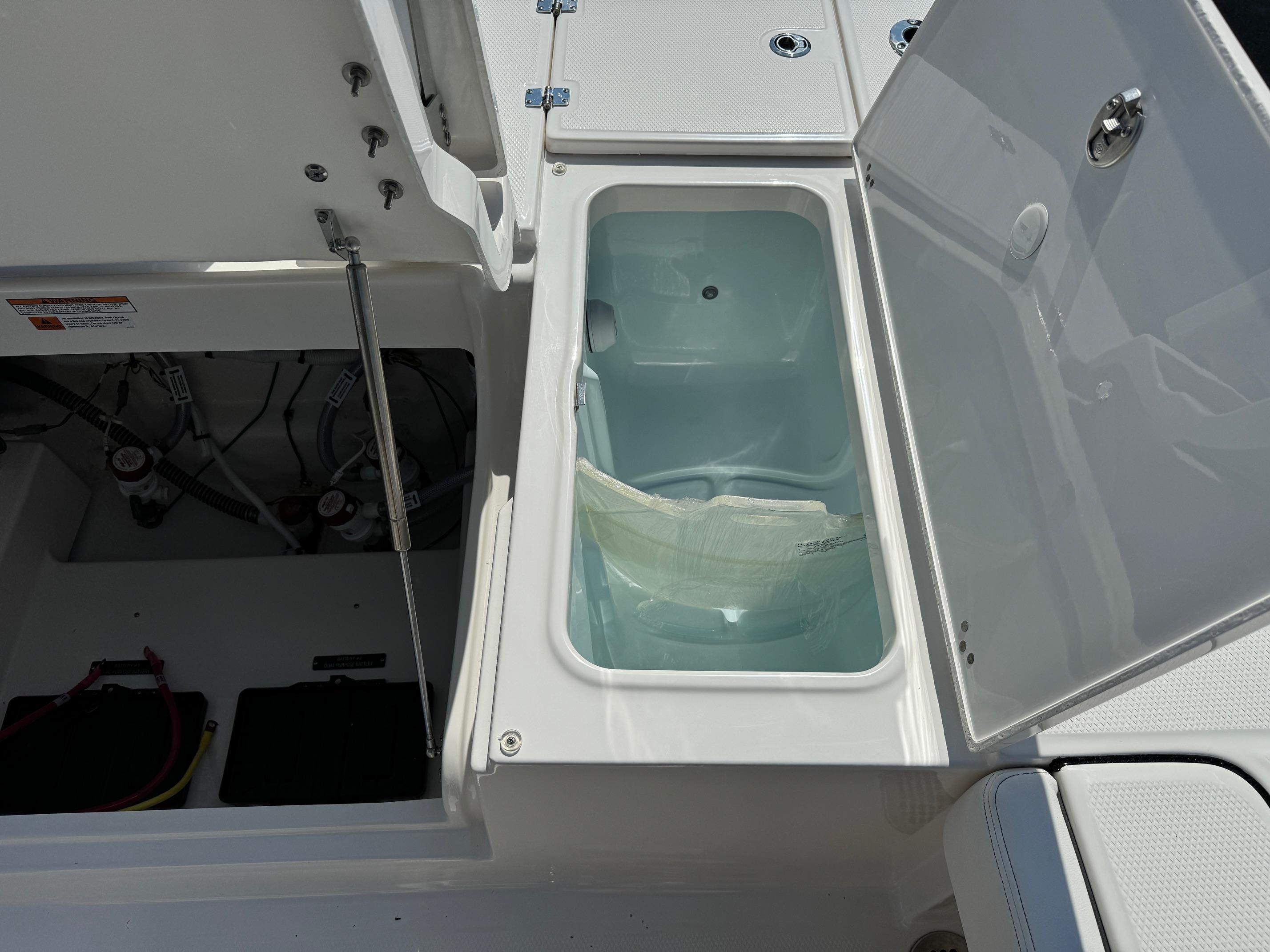 2025 Robalo R246 CAYMAN boat storage compartment with open lid, showcasing interior details.