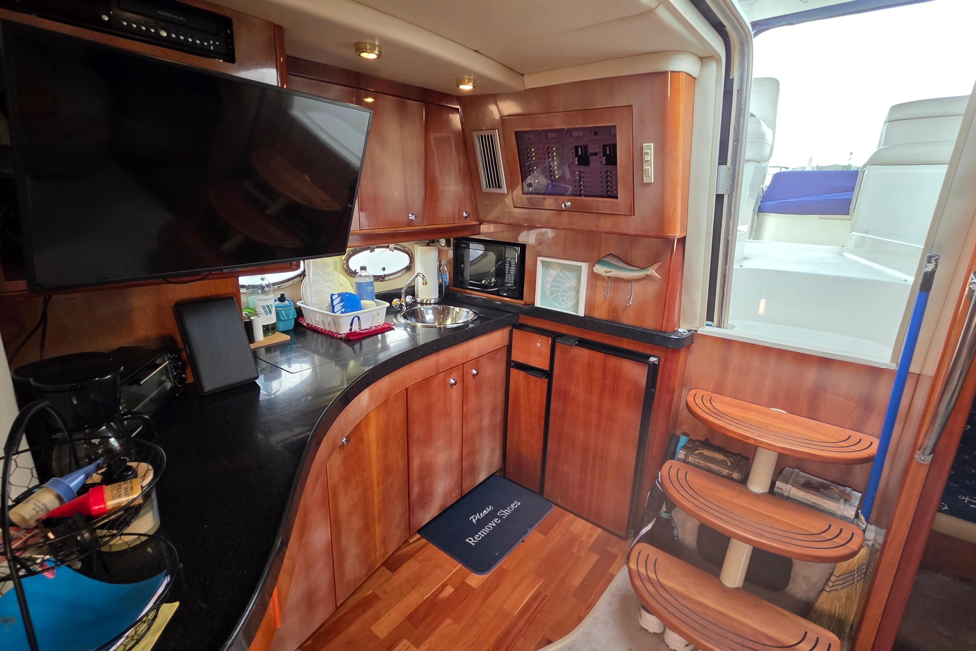 Luxurious 2002 Regal Commodore 4260 yacht interior with modern kitchen and wooden accents.