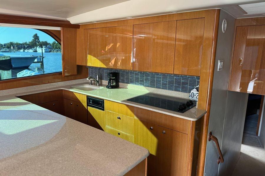 Luxurious kitchen interior of 2002 Viking 61 Enclosed Bridge yacht with wood cabinetry.