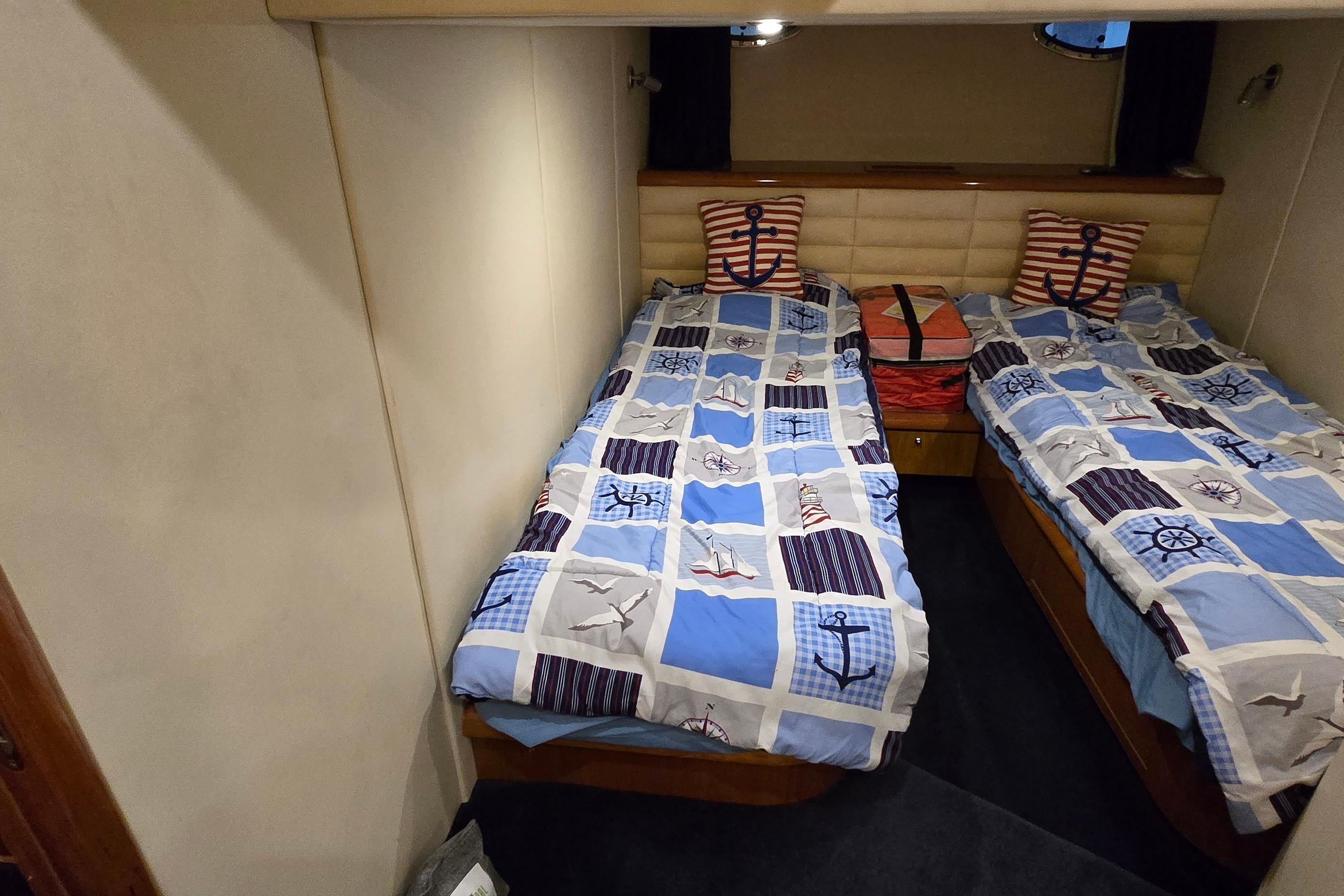 Twin cabin with nautical-themed bedding in 2004 Sunseeker Camargue 50 yacht.