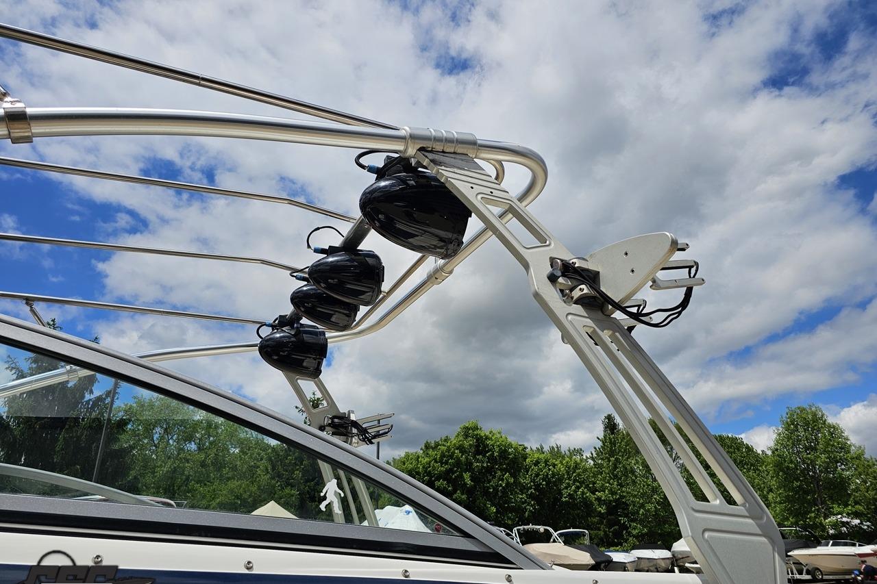2010 Cobalt 232 WSS boat with wakeboard tower against a cloudy sky.
