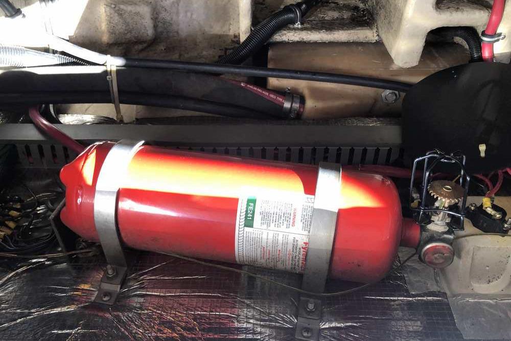 Engine compartment of a 1999 Regal Commodore 2760 with a mounted fire extinguisher.